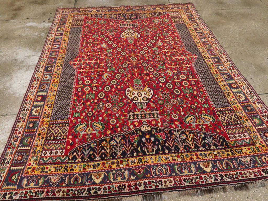 A vintage Persian Shiraz Accent rug. This finely woven rustic carpet was woven by the Qashkuli subtribe of the Qashqai in southern Persia. It is a vertically doubled millefleurs prayer rug with side half cypress columns and a vase on a mound at each