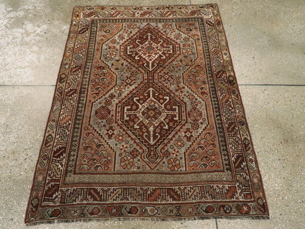 Ein alter persischer Shiraz-Teppich. Dieses kleine südpersische Stammesmuster hat ein mit Boteh bestreutes hellrot-braunes Feld, das ein gekniffenes graublaues Unterfeld trägt, das wiederum von einem einfachen braunen Stabmedaillon aus zwei