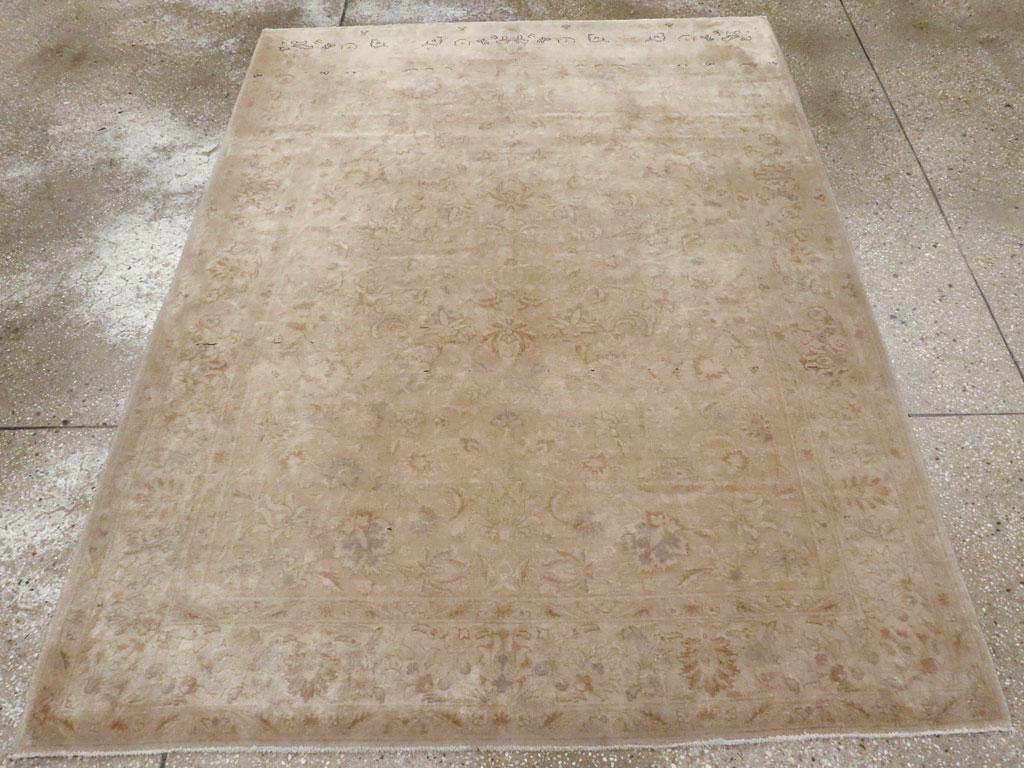 Una alfombra de acento persa Tabriz vintage. Numerosos estilos de palmetas de hojas y pétalos, generalmente delineados en marrón, flotan sobre el campo de color topo claro de esta alfombra urbana Tabriz con dibujos en toda la superficie, de trama