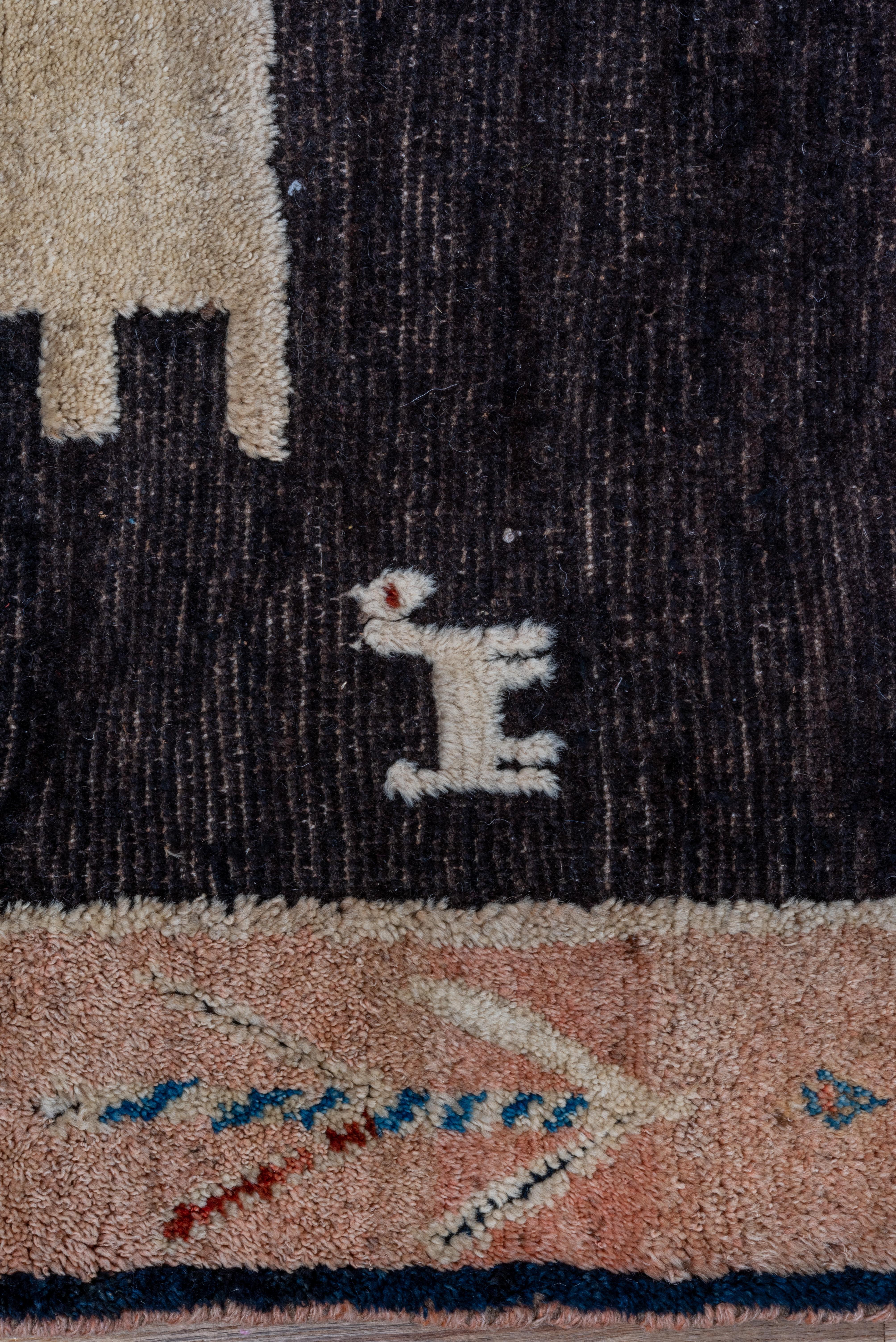 The neatly abrashed charcoal brown field of this endearing southwest Persian tribal scatter shows four ambiguous animals around a comb-fringed rectangle, while the tan main border shows more animals, probably sheep or goats along with short lozenge