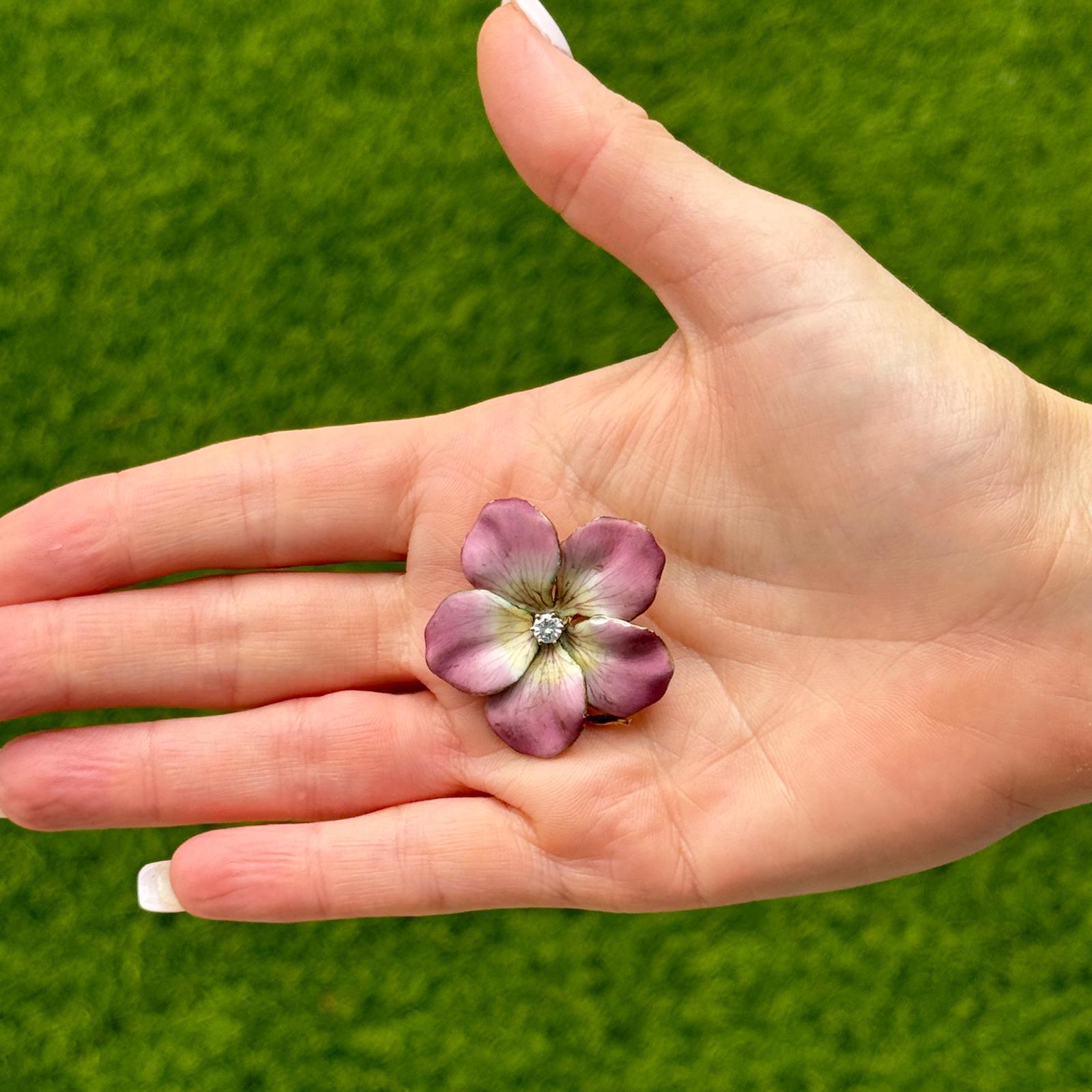 Mid-20th Century Pink Enamel and Diamond Pansy Brooch Pin is a beautifully crafted piece in 14 Karat Yellow Gold. The brooch showcases a delicate pansy flower design, adorned with pink enamel that adds a pop of color and depth. At the center of the