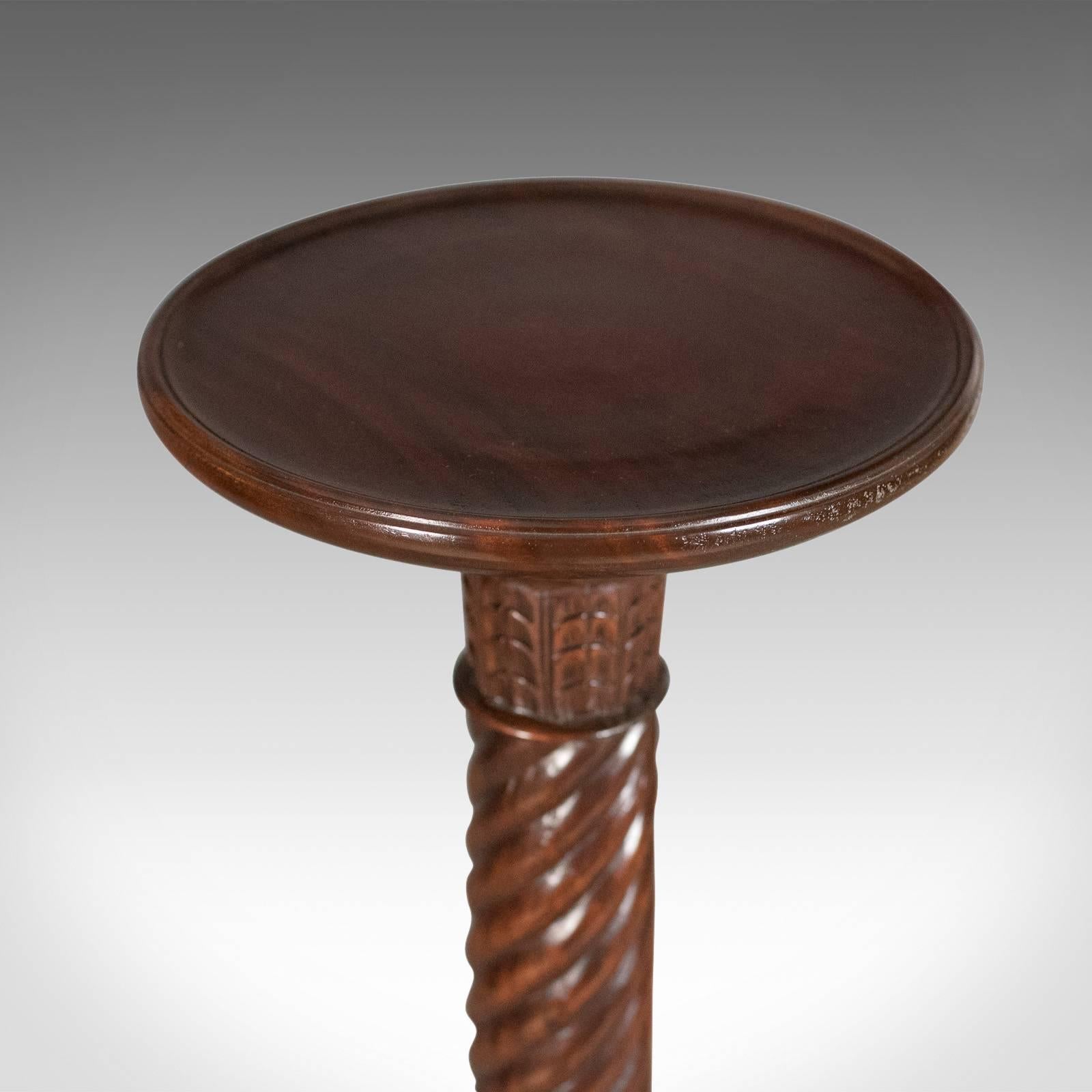 This is a mid-20th century plant stand, a William IV revival torchère in dark mahogany.

Well executed in a quality dark mahogany 
Good color with a lustrous wax polished finish
Robust ring turned baluster column with helical twist

Standing