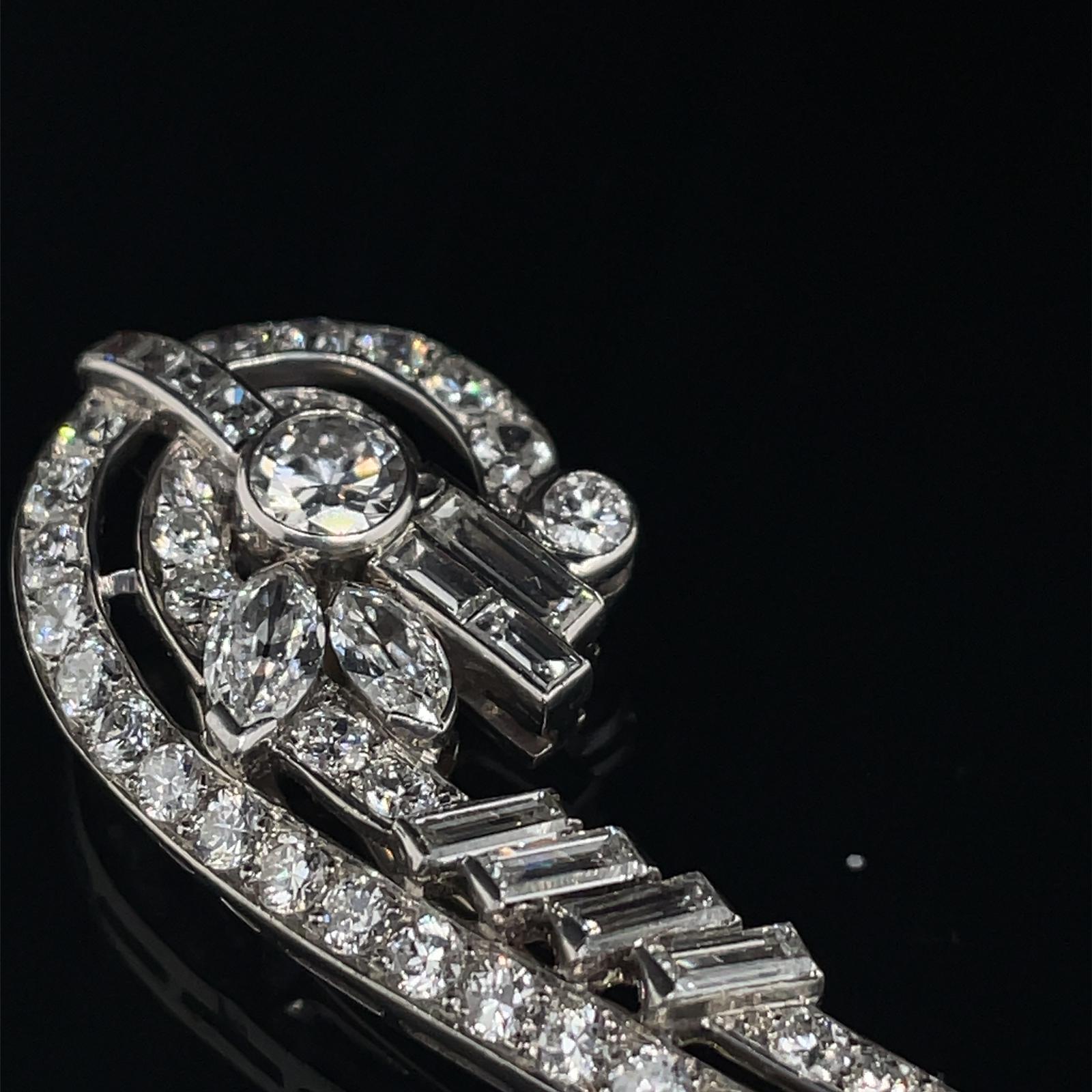A Mid 20th century platinum diamond hairclip.

This beautiful Mid 20th Century Hair Clip/Brooch in the Art Deco style, is made in France.

Designed as a gently curved elongated wing shape, grain set with transitional cut diamonds along its length