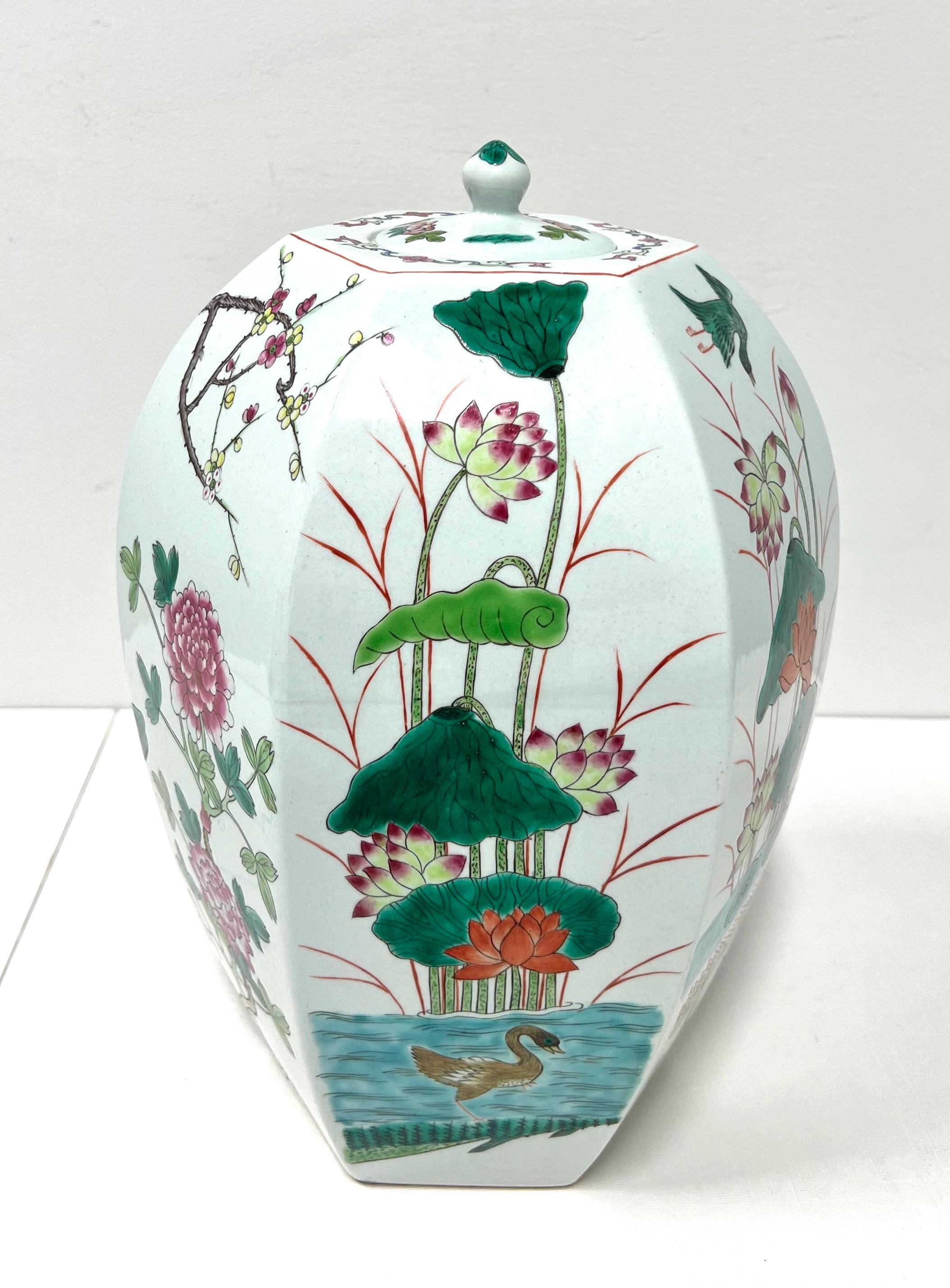 An Asian Chinoiserie style ginger jar with lid, unbranded. Fine porcelain body in a hexagon shape, hand painted with a multi-color Chinoiserie scene and a tiny round handled lid. Likely made in China, in the mid 20th Century.

Measures:  9.5w 9.5d
