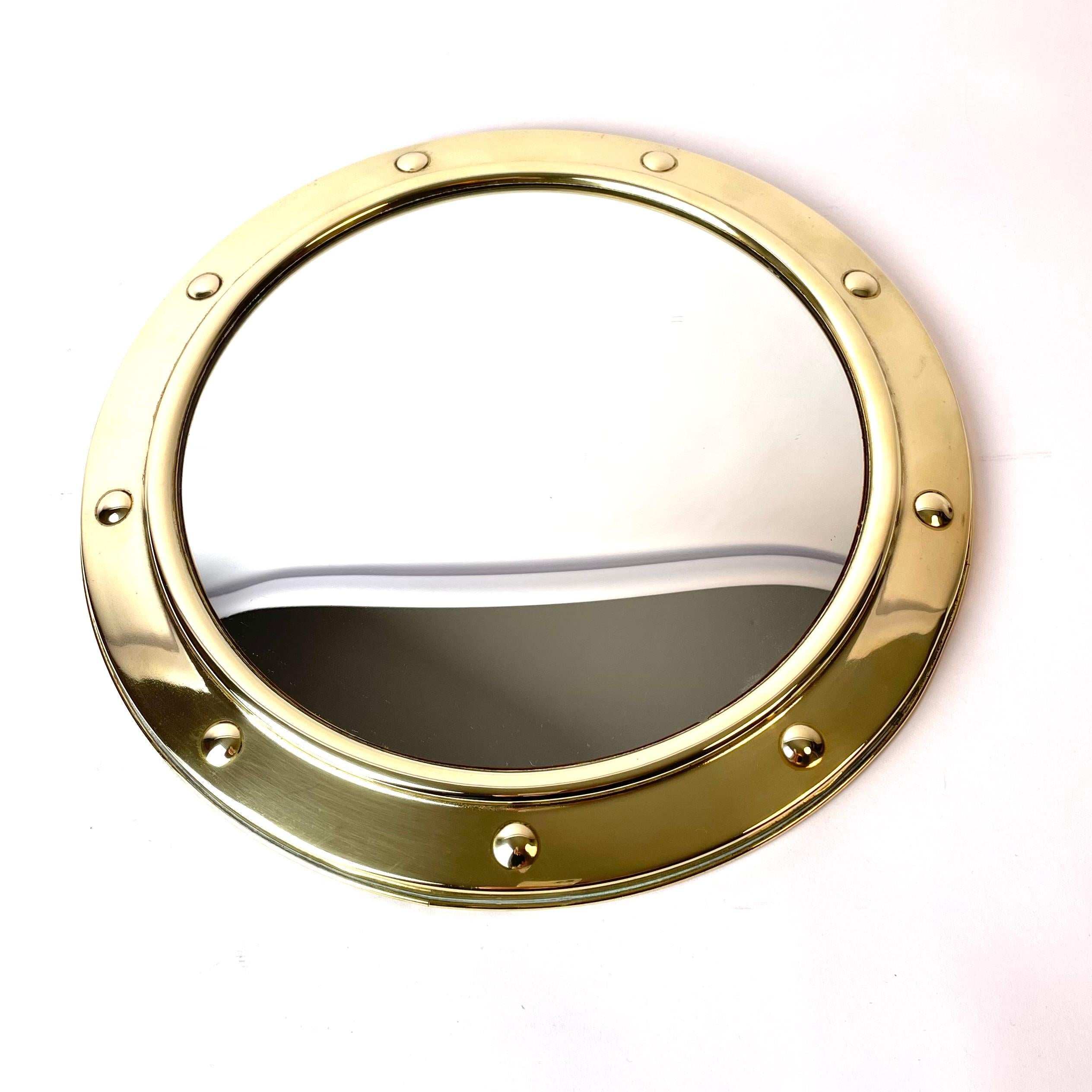 A beautiful mid-20th century porthole convex wall mirror in brass, made by Linton in England, probably in 1940s-1950s.

The mirror is in good condition, but has a small dent on the underside of the mirror (see picture). The dent is not visible when