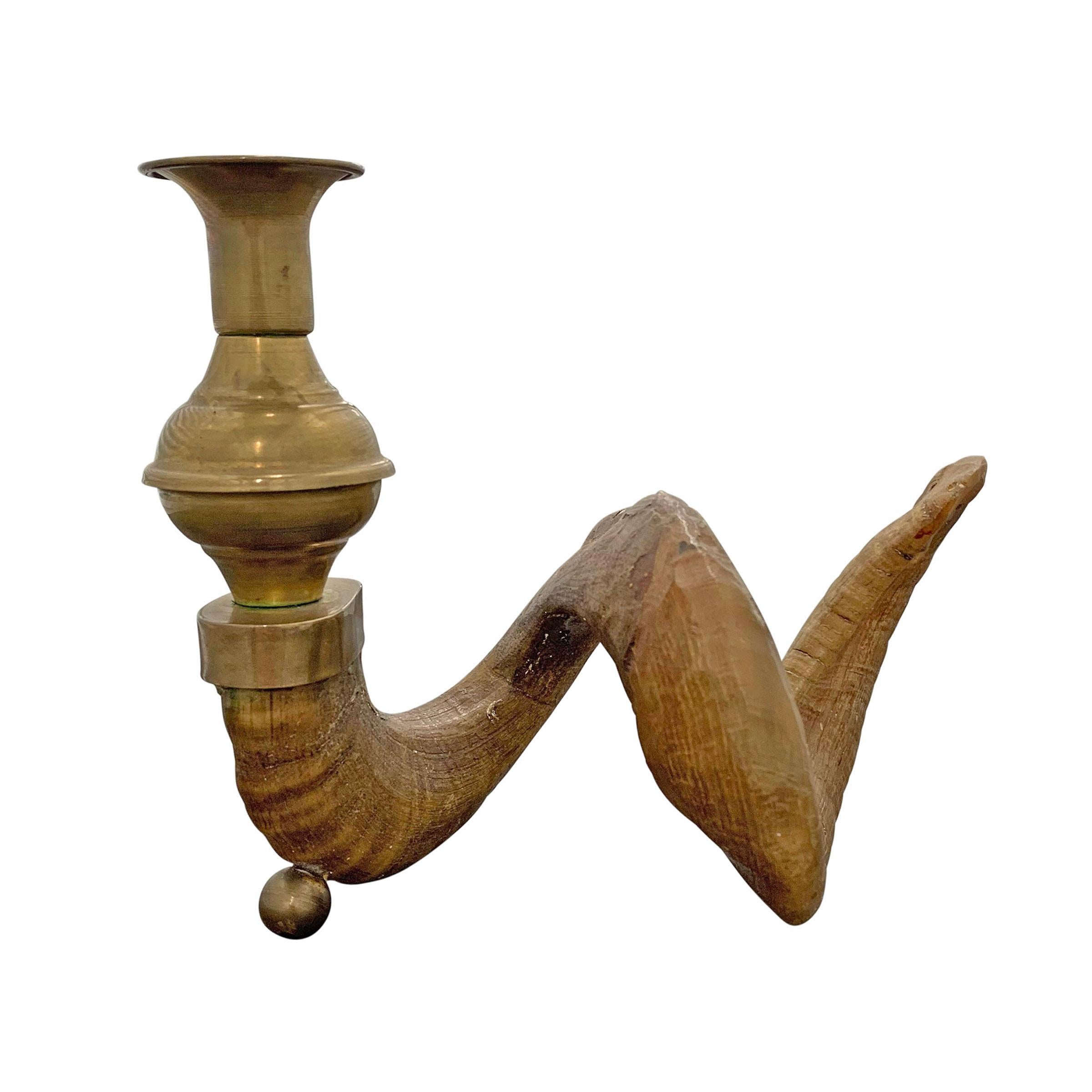 A fantastic mid-20th century American ram's horn candlestick with brass fittings resting a brass sphere foot.