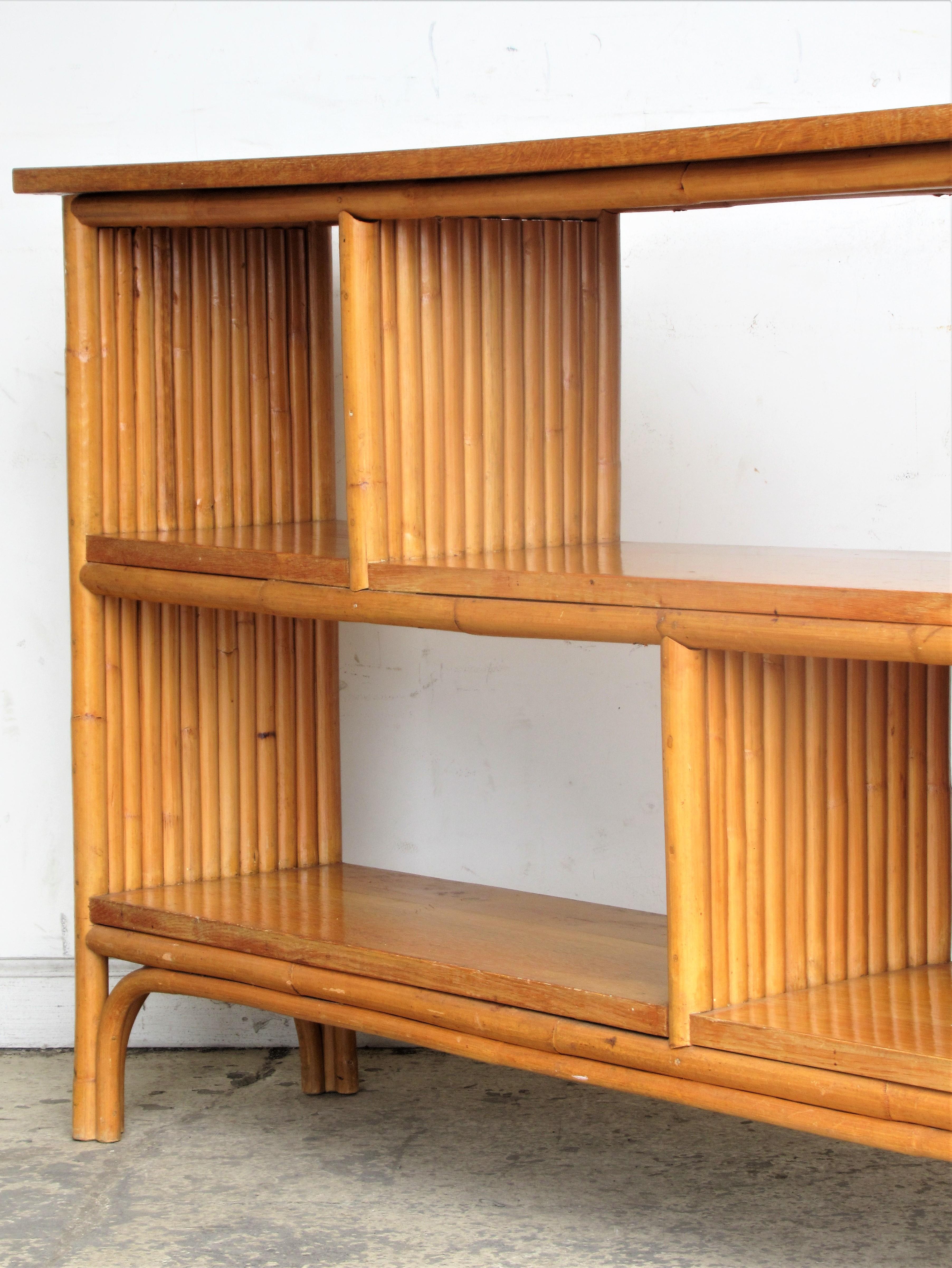 A divided four section rectangular rattan and quarter sawn oak bookcase in beautifully aged original glowing surface color. A hard to find modernist piece of rattan  furniture with exceptionally fine quality construction. Paul Frankl design, made in