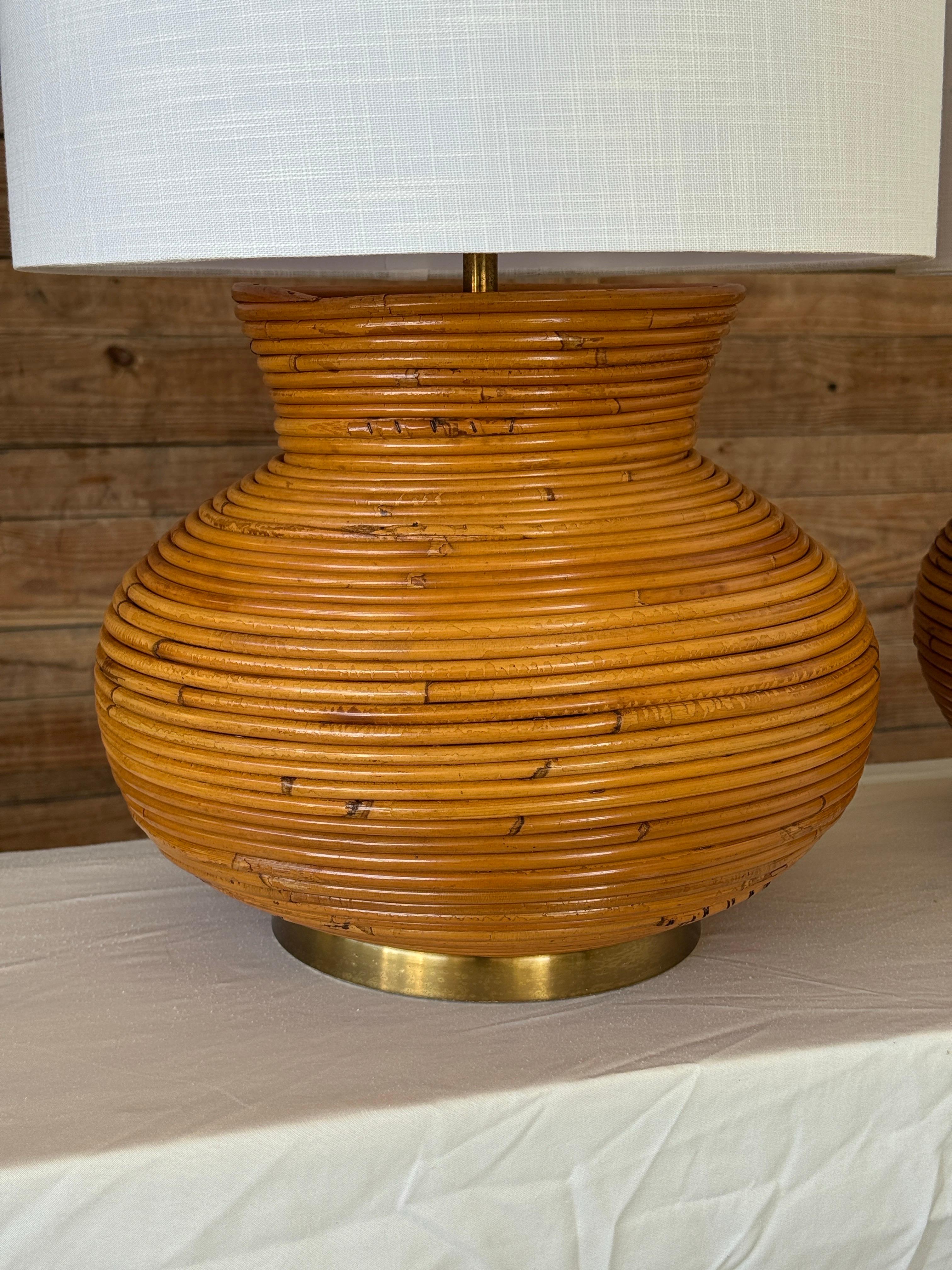 Une paire sculpturale de lampes gourdes en rotin refini dans le style Organic Modern, présentant une silhouette enroulée à la main avec une finition chaude et mielleuse et des bases en laiton massif.
Ces lampes offrent une forme saisissante et une