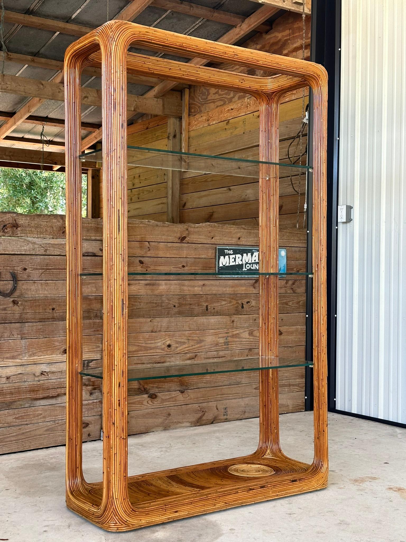 Squisita Etagere in rattan Reed a matita di grandi dimensioni con tre ripiani in vetro in eccellenti condizioni di rifinitura.
Fantastico pezzo realizzato a mano in Honduras con dettagli intricati e tonalità di marrone e marrone con il