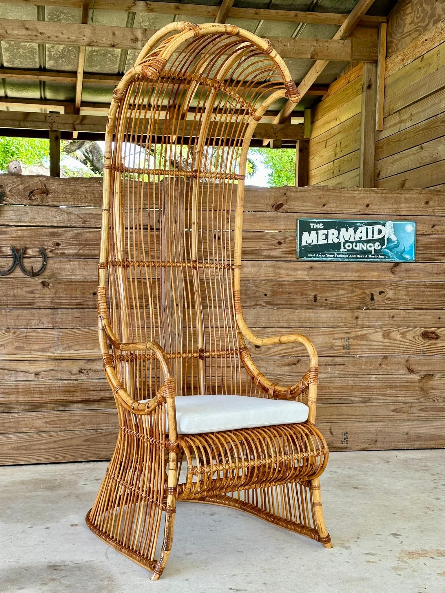 Introducing an exquisite vintage bent rattan canopy armchair, meticulously refinished and restored to its former glory. This stunning piece features a brand-new custom upholstered cushion, crafted from durable white Sunbrella fabric. The cushion