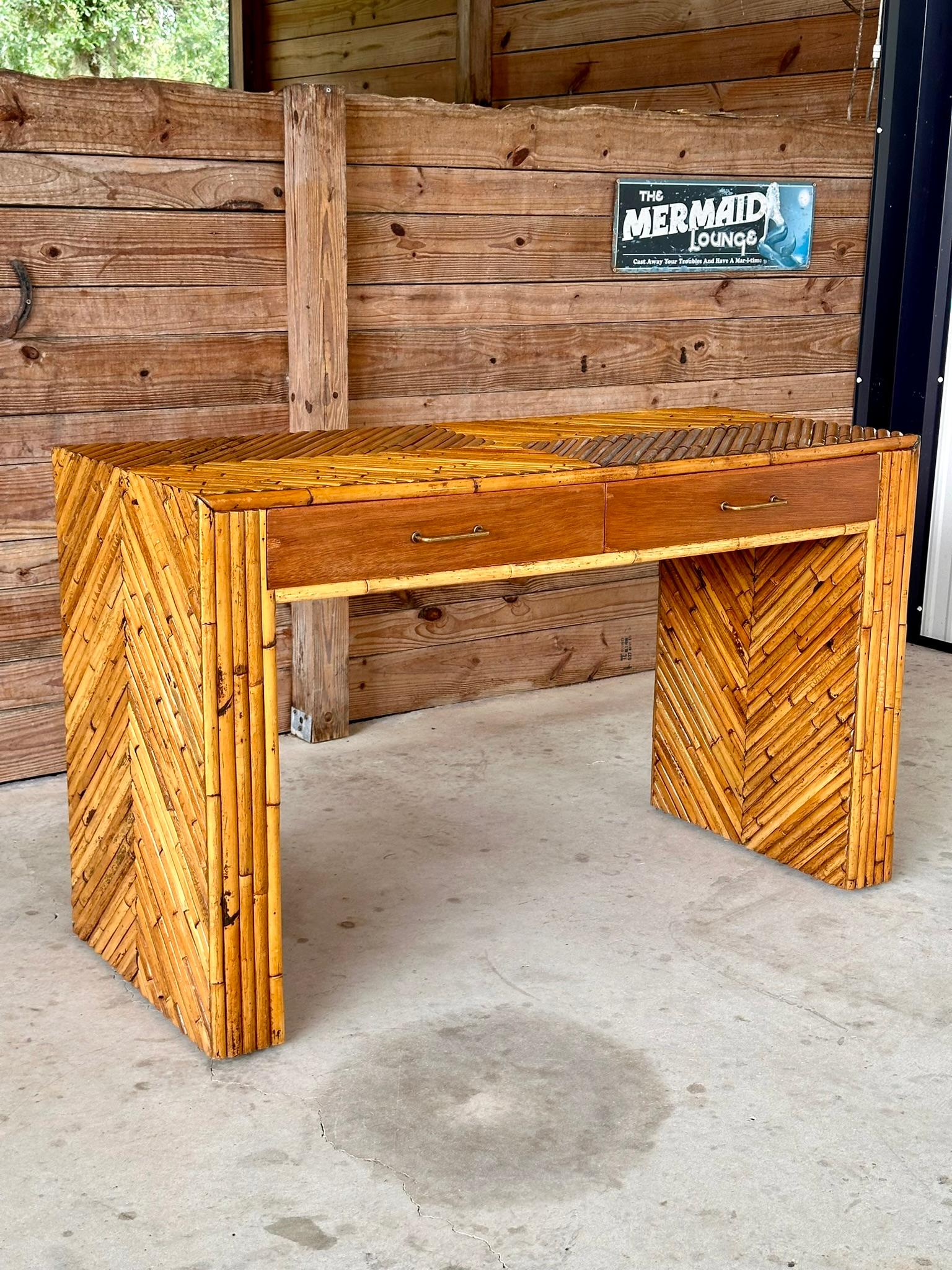 Add a touch of vintage elegance to your space with this Refinished and Restored 1960s Split Rattan Two Drawer vanity or desk.
Featuring a striking chevron pattern and a sleek floating design, this piece exudes mid-century charm and