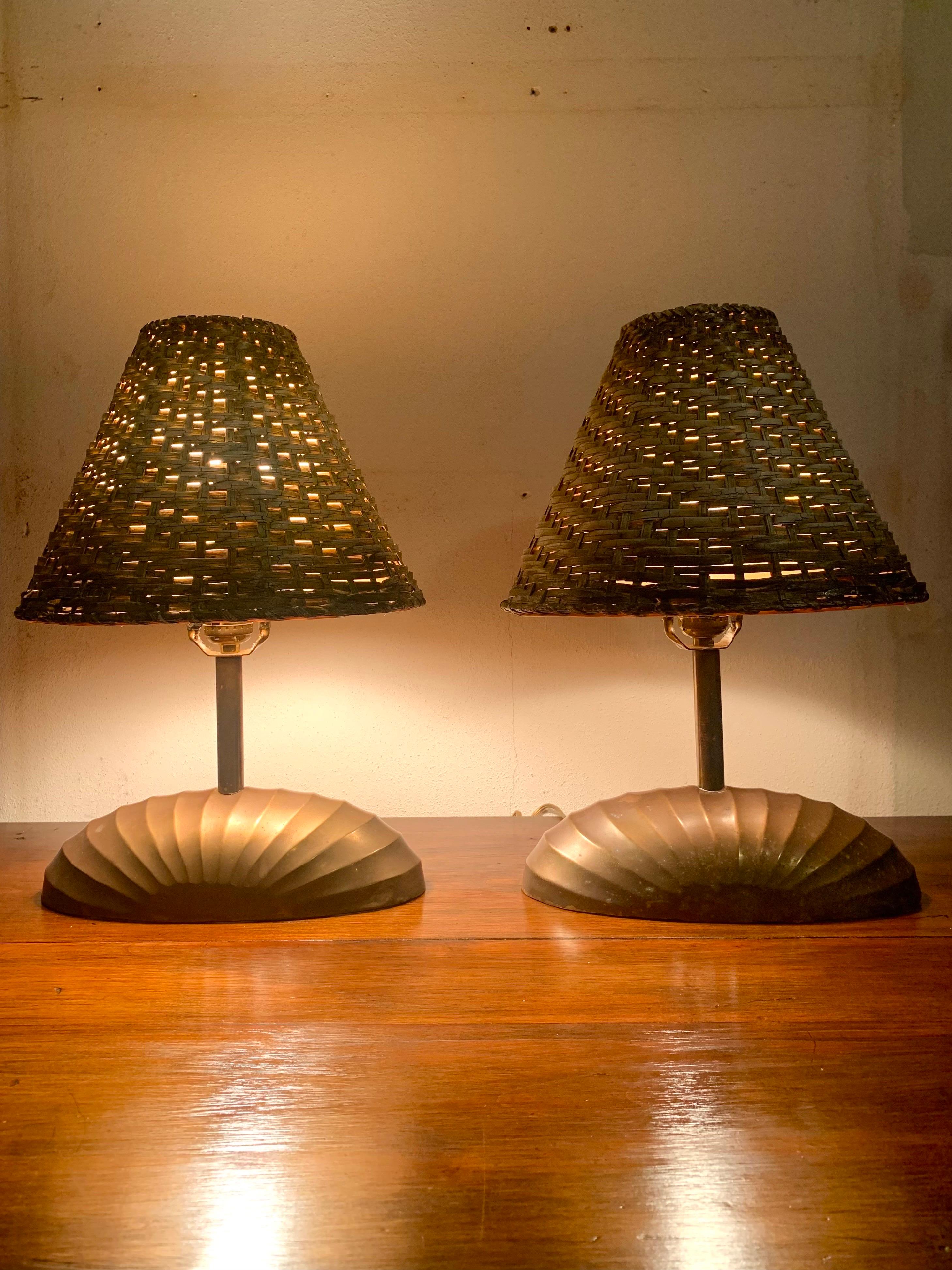 Beautiful pair of brass regency lamps with a shell motif. Both have a vintage lacquered woven cane shade. The lamps have a beautiful patina that has built over the years. They are brass so could be polished if desired. 

Would fit well with other