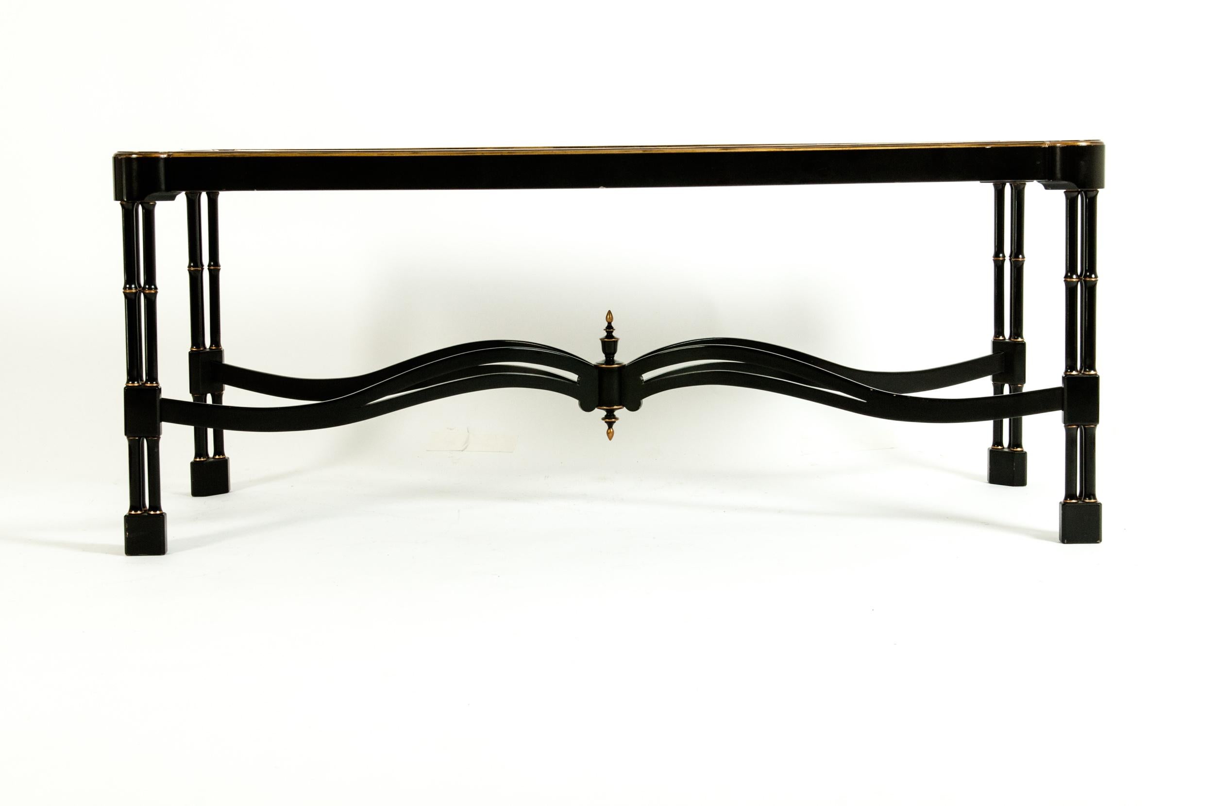 Mid-20th century style lacquered & gilt gold decorated design details Italian coffee table having X-form base stretcher. The table is in excellent vintage condition. Minor wear consistent with age / use. The table measure about 50 inches long x 20