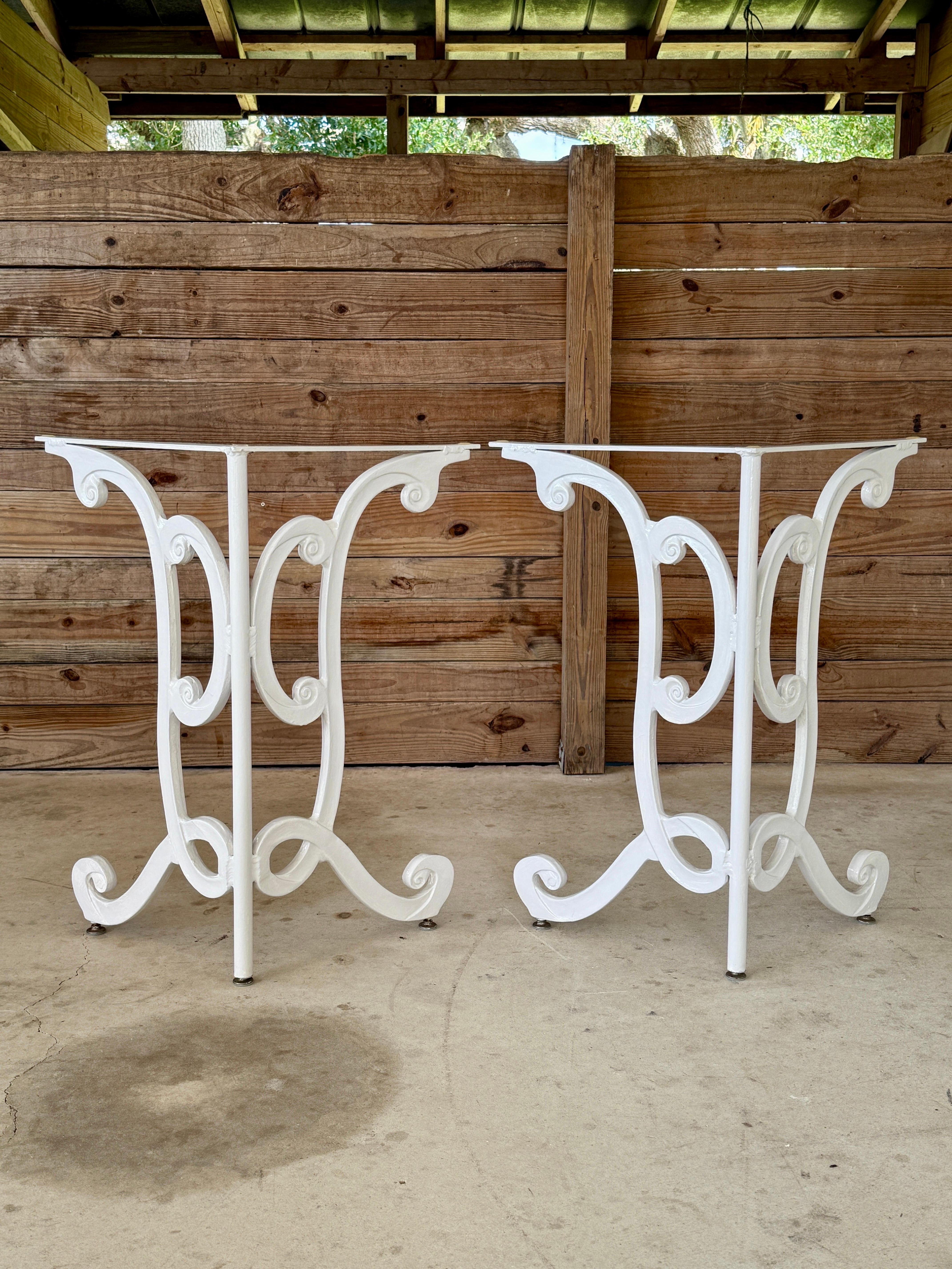 A pair of Mid-20th Century cast aluminum table bases with elegant scroll detailing, previously painted in white with a gloss finish. Originally intended for outdoor use, these versatile bases can support a glass or stone top to create a dining or