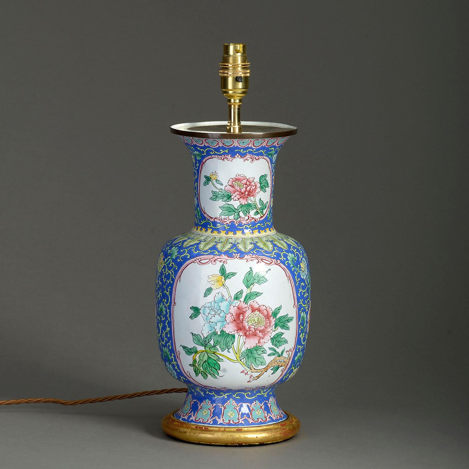 A mid-20th century Canton enamel vase of baluster form, the blue ground with scrolling foliage and set with floral cartouches. Now mounted as a table lamp on a hand-turned water gilded base.

Republic Period.

Dimensions refer to size of enamel