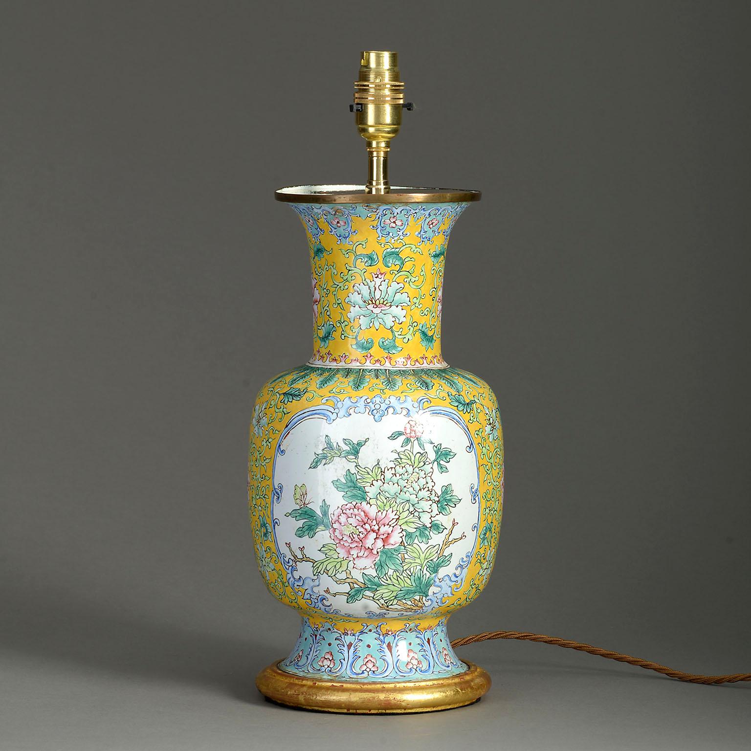 A mid-20th century Canton enamel vase of baluster form, the Imperial yellow ground with scrolling foliage and set with floral cartouches, mounted as a table lamp on a hand-turned water gilded base.

Republic Period.

Dimensions refer to size of