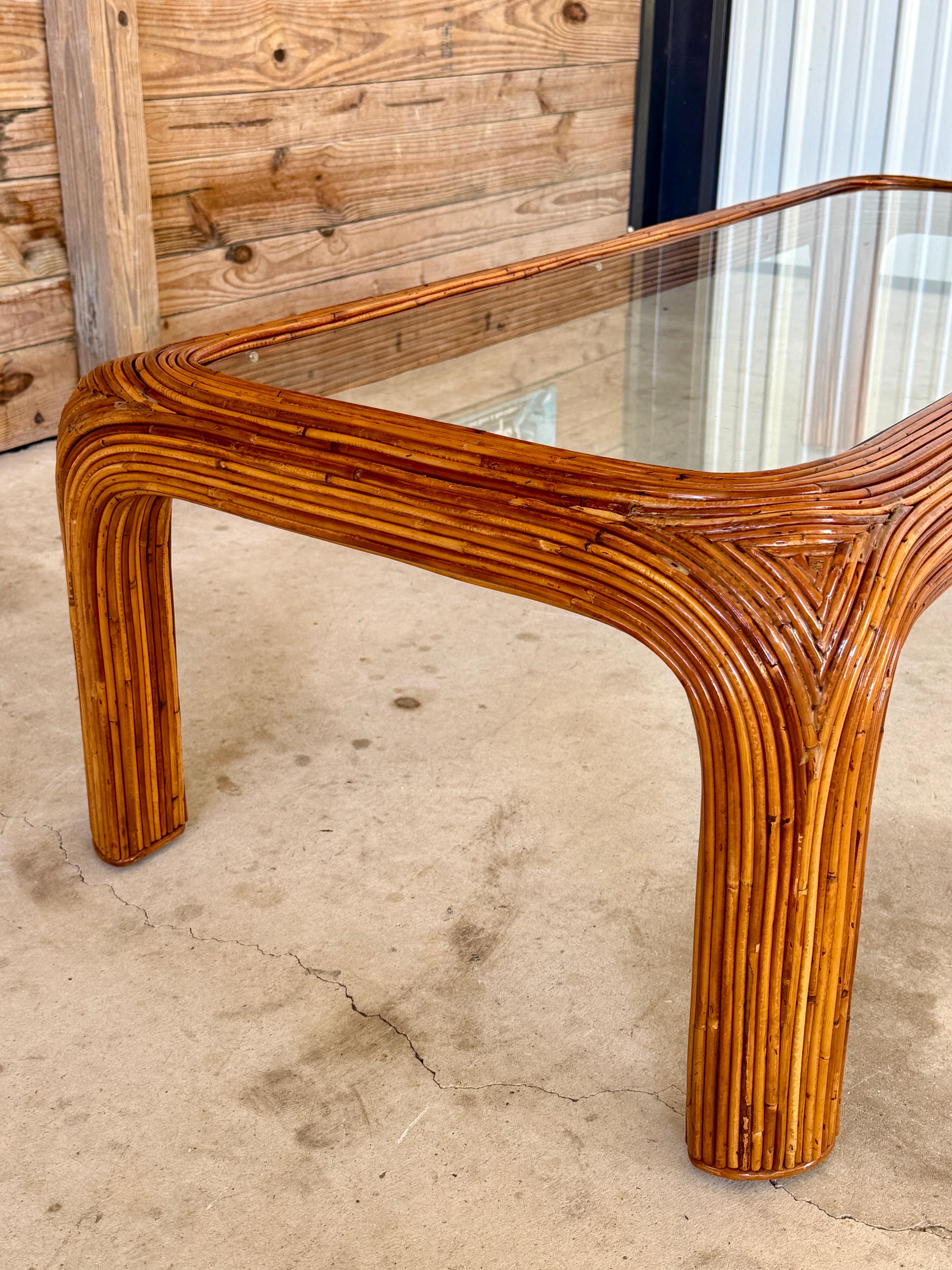 Dieser organisch-moderne Couchtisch ist ein wunderschön restauriertes Beispiel für die Handwerkskunst der Mitte des 20. Jahrhunderts und zeichnet sich durch eine skulpturale Silhouette aus, die vollständig mit feinem Bleistiftrohr-Rattan umwickelt