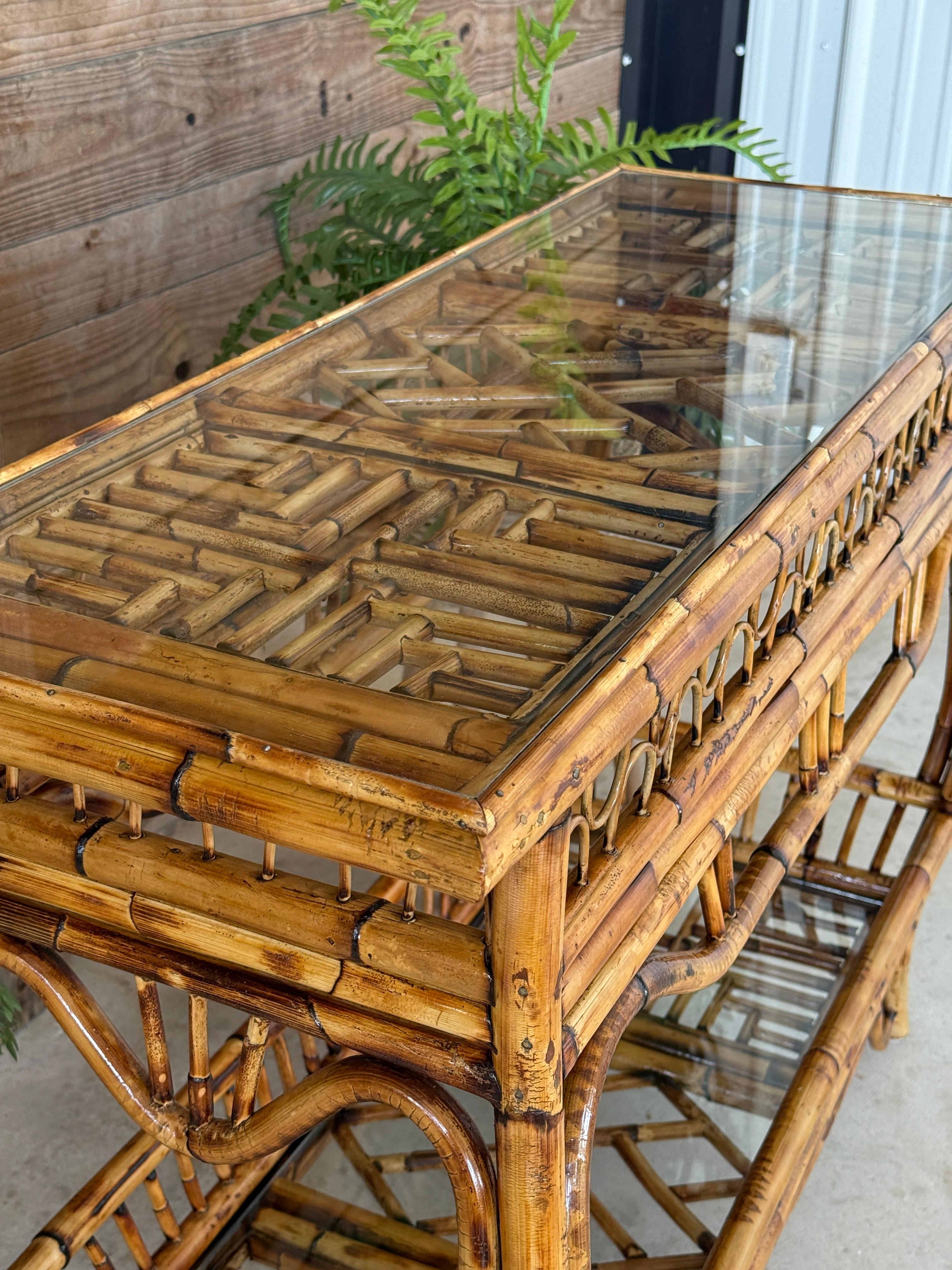 Un'impressionante consolle a traforo in rattan della metà del XX secolo in stile Chippendale, completamente restaurata per mostrare il suo fascino organico e moderno. Caratterizzato da intricati dettagli a traforo, supporti graziosamente curvi e due