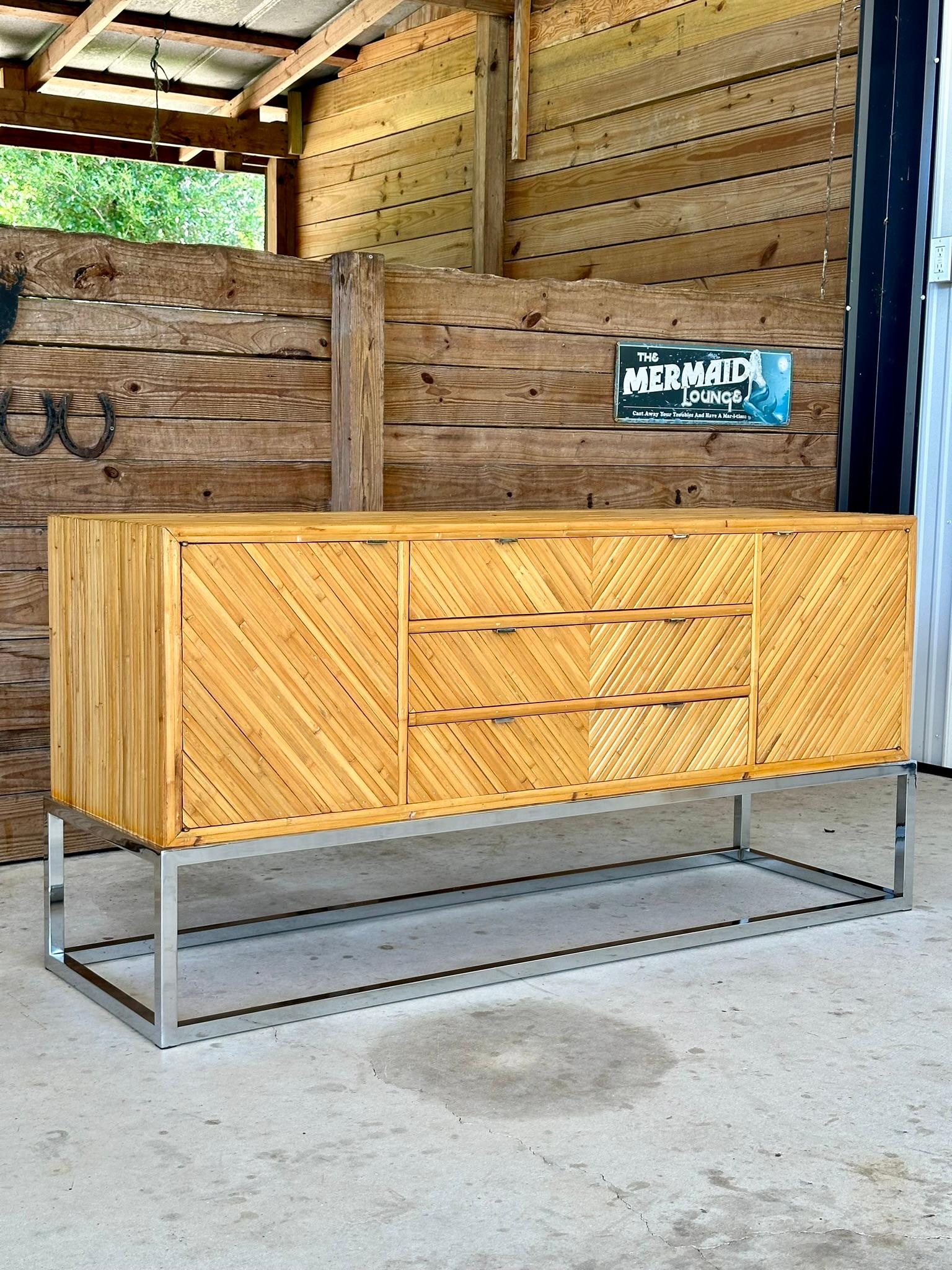 Introducing a stunning credenza, elegantly veneered with diagonally applied split bamboo atop a chrome base, creating a floating design that is also finished on the back. Embracing an organic modern style, the top piece has been meticulously