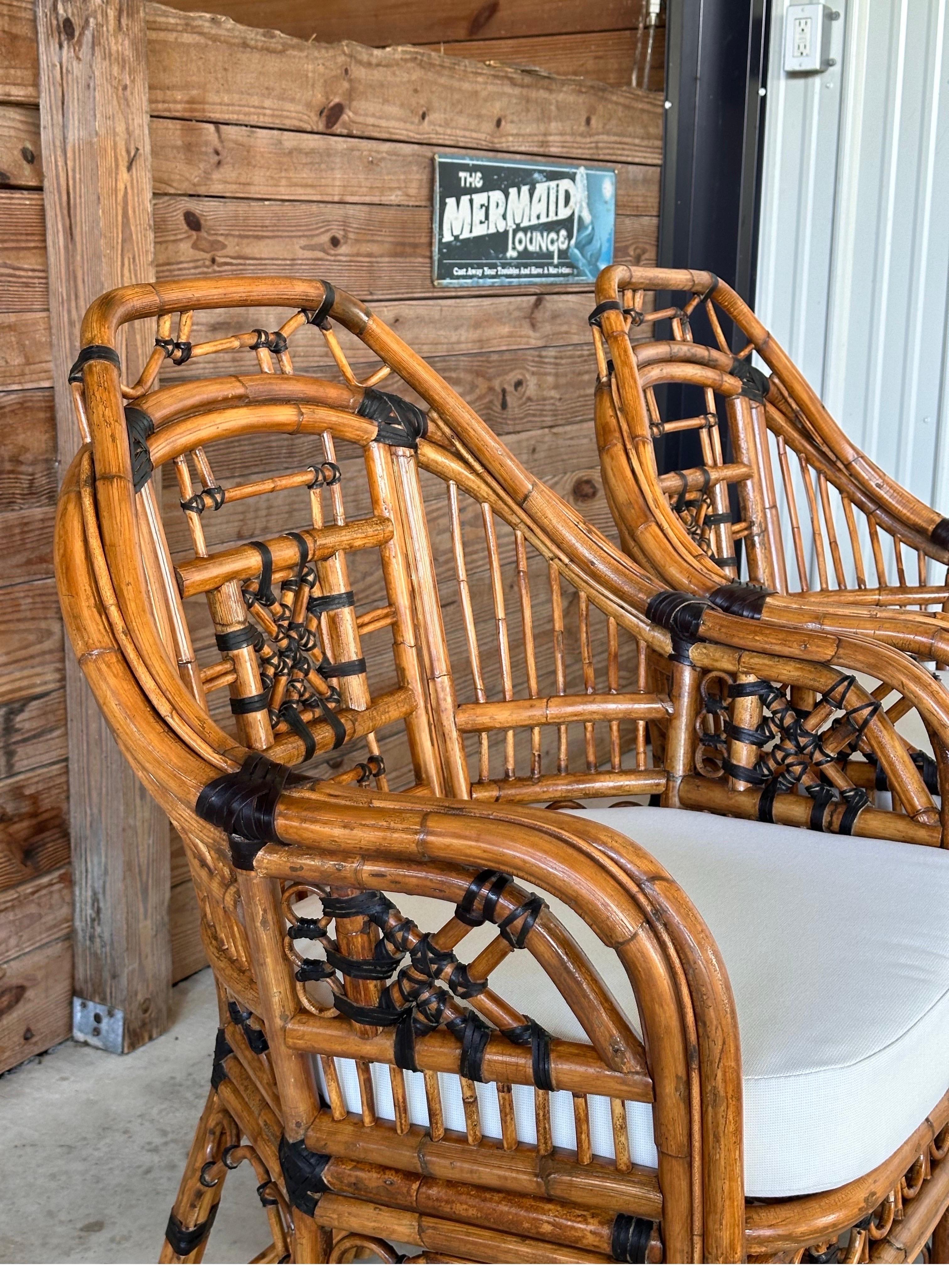 Step into a world of classic elegance with this stunning pair of Mid-20th Century rattan side arm chairs. Fully restored and refinished, these chairs exude timeless sophistication with their intricate fretwork and Chippendale details. The