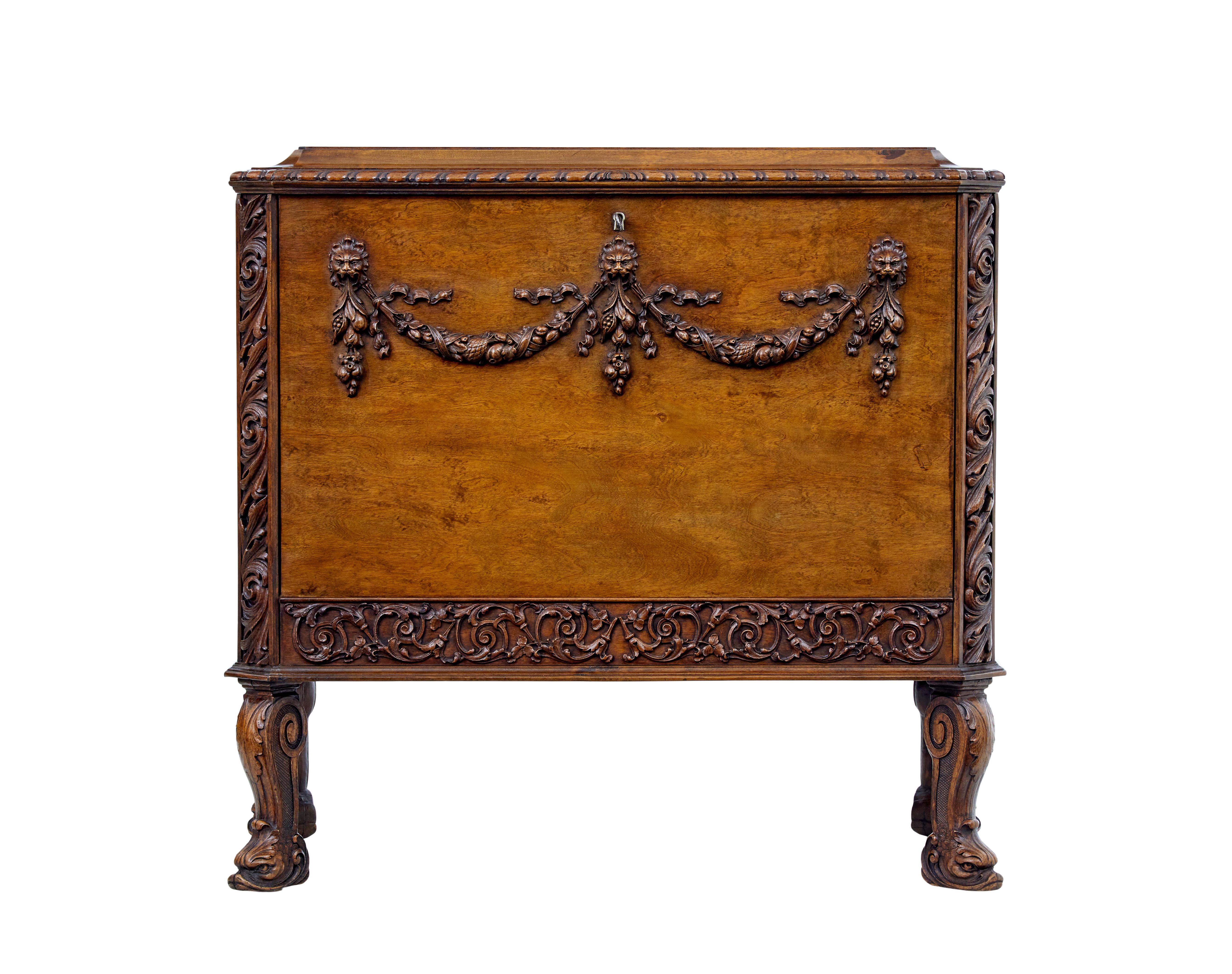 Carved Scandinavian concealed chest of drawers circa 1940.

Designed in the Rococo style with drop down front to reveal 2 fitted birch drawers. Canted corners with applied carvings. Applied swag carvings to the front with lion heads. Standing on 4