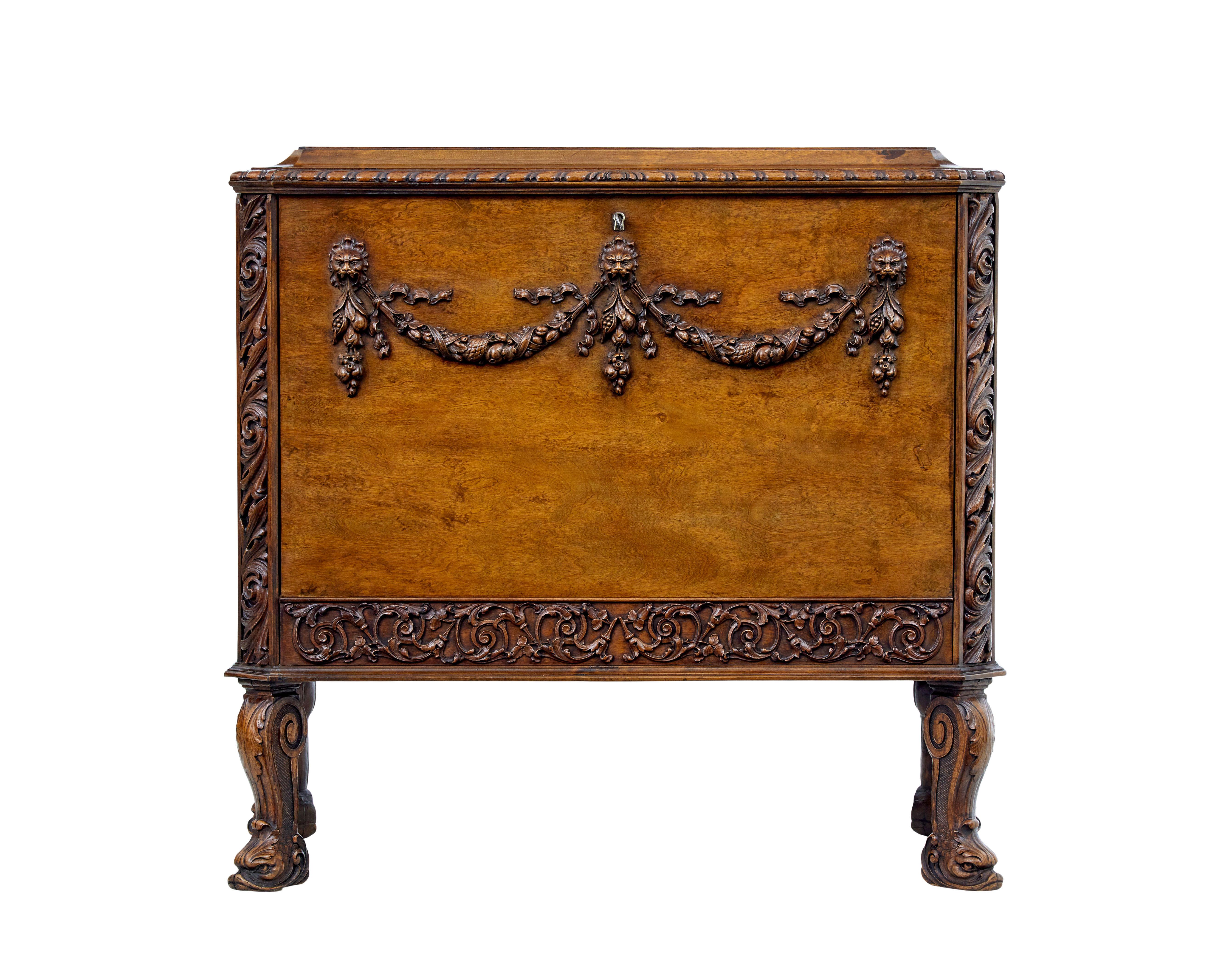 Carved Scandinavian concealed chest of drawers circa 1940.

Designed in the rococo style with drop down front to reveal 2 fitted birch drawers.  Canted corners with applied carvings.  Applied swag carvings to the front with lion heads.  Standing on