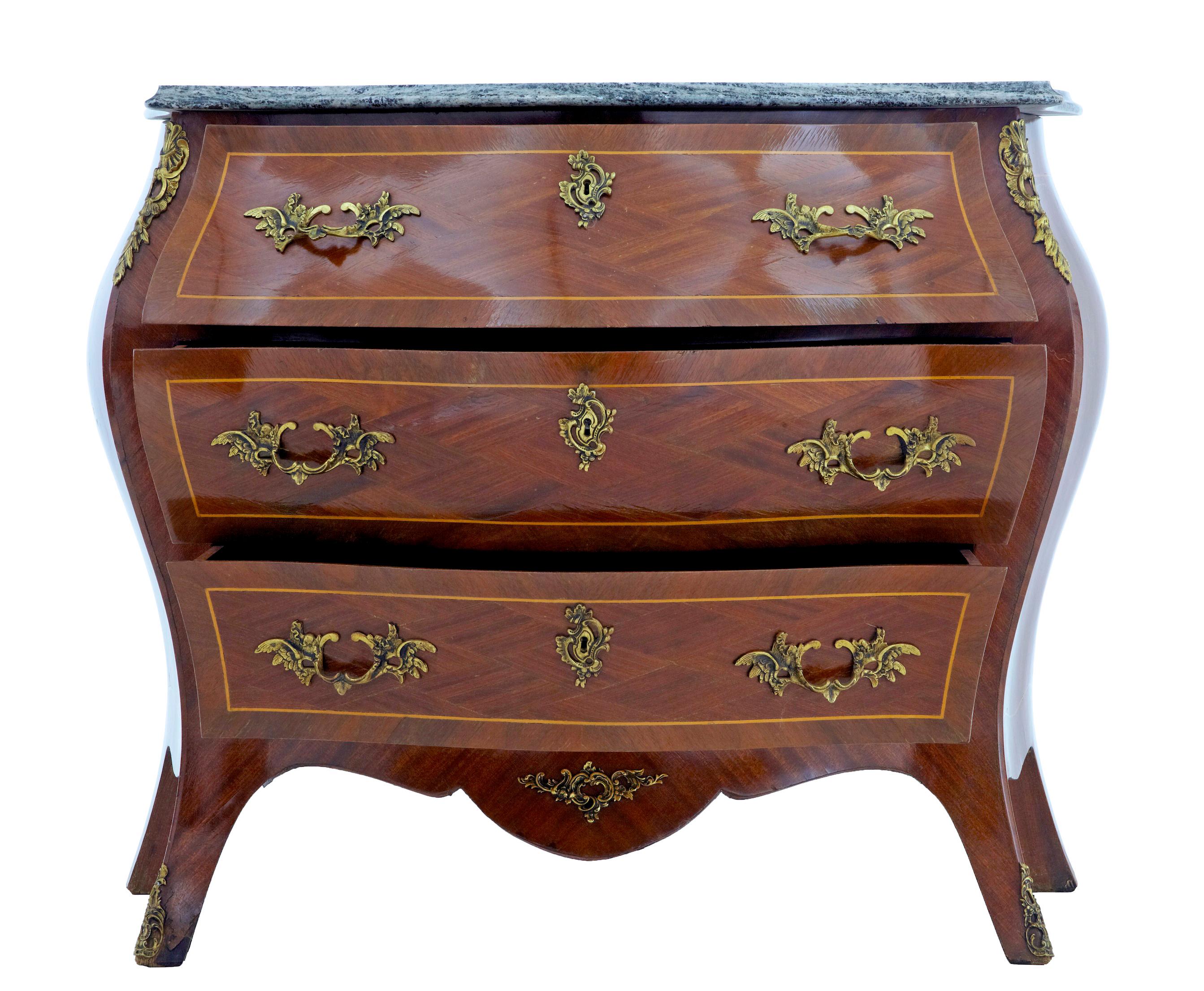 Mid 20th century rococo revival kingwood commode circa 1950.

Bombe shaped 3 drawer commode with shaped marble top. Green and grey marble is loose fitting for easier movement.

Arranged mahogany veneers with stringing and kingwood cross banding.