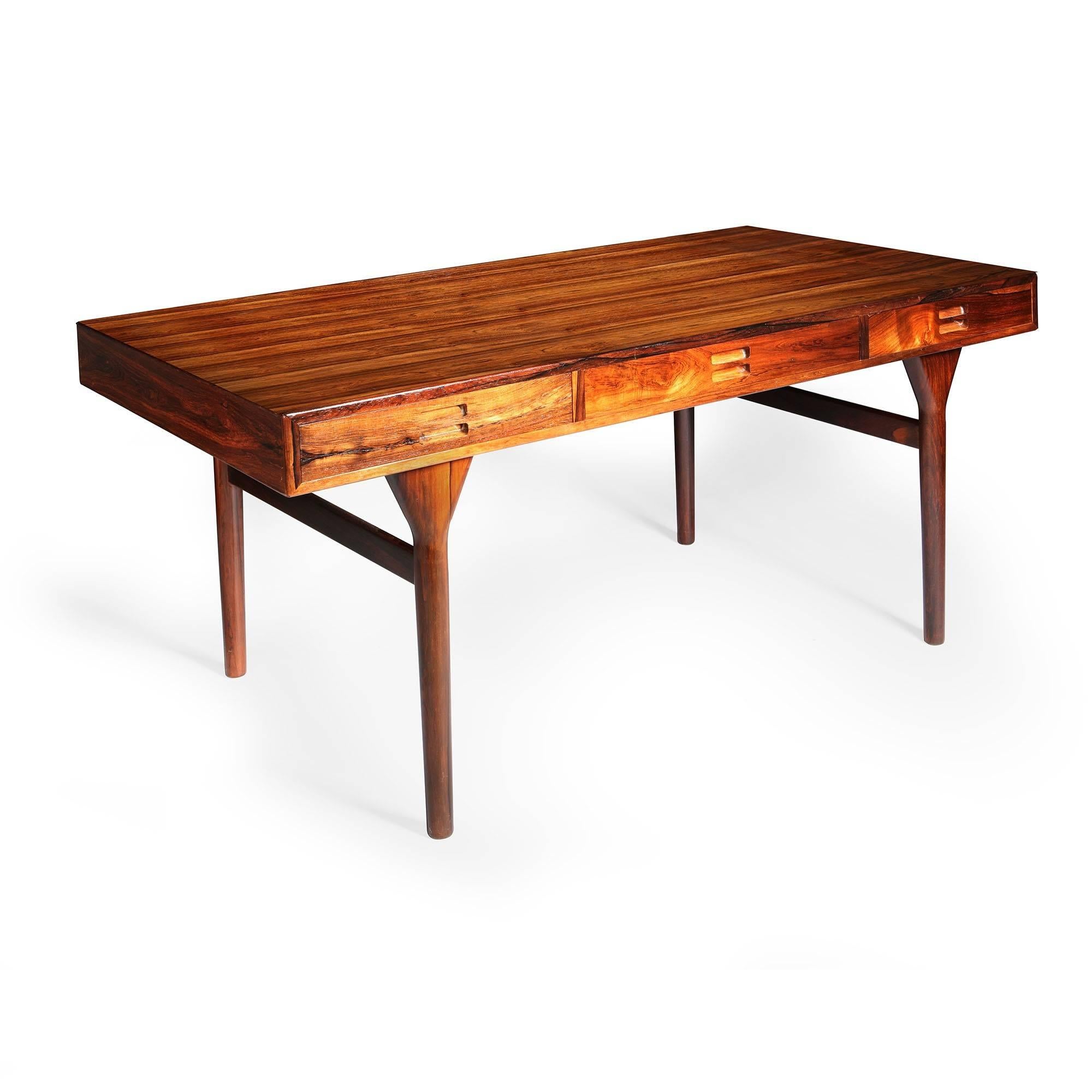 A mid-20th century Danish rosewood desk, with three drawers to the frieze and finely figured top. Designed by Nanna Ditzel in 1958 for Soren Willadsen.