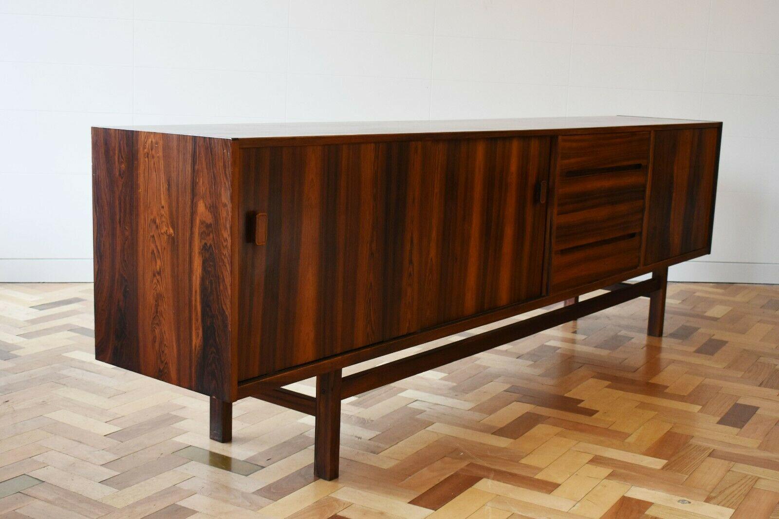Mid 20th century rosewood sideboard designed by Nils Jonsson for Troeds.

This fabulous sideboard was designed in Sweden by Nils Jonsson for Hugo Troeds in the 1960s/70s. It features a stunning deep brown rosewood, with an intricate wood patterned