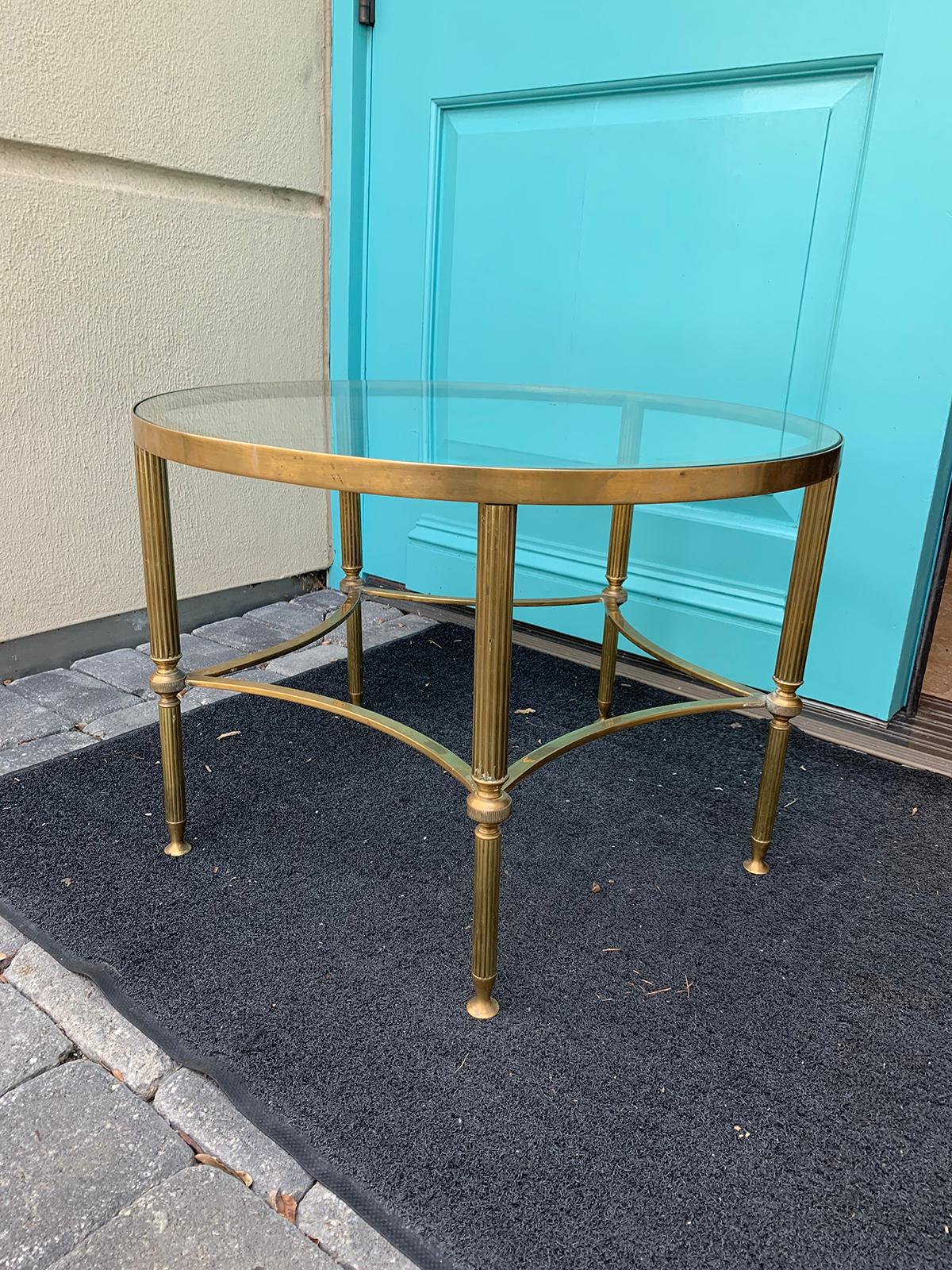 Mid-20th century round brass coffee table, glass top, in the style of Baguès.