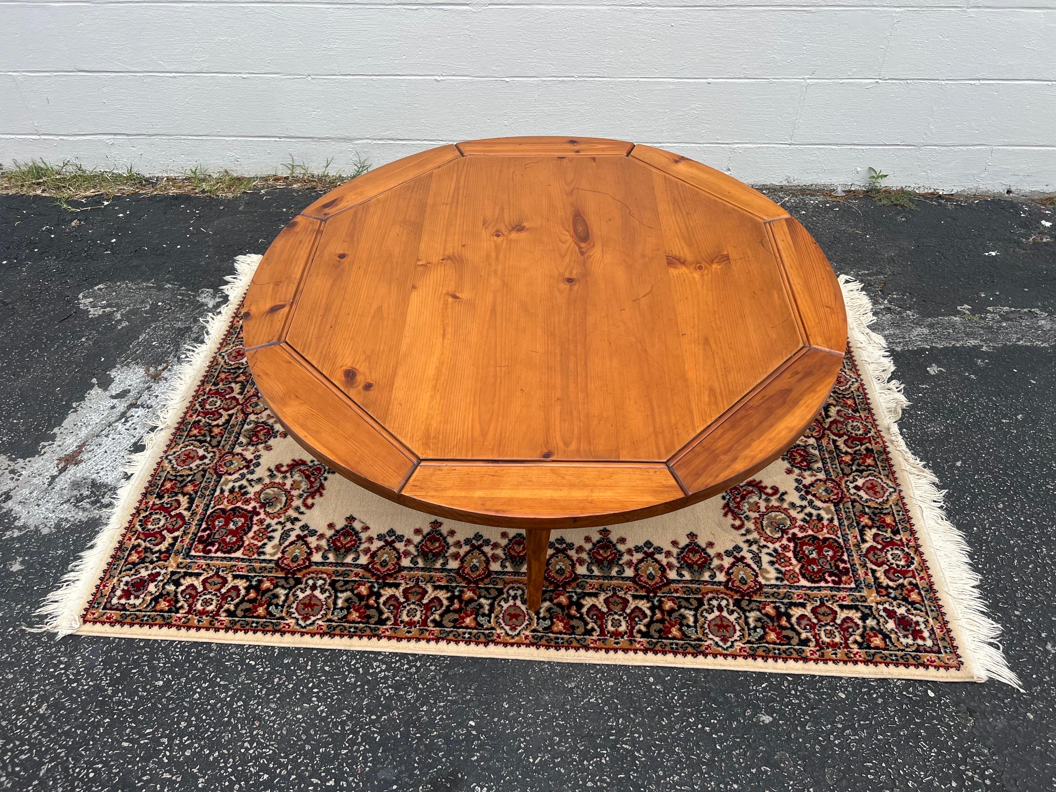 Newly refinished, this round pine coffee table mid-20th century is definitely unique. It has classic mid-Century modern lines with splayed leg’s except the top has grooves making it appear to be octagonal in shape, when it is actually round. The
