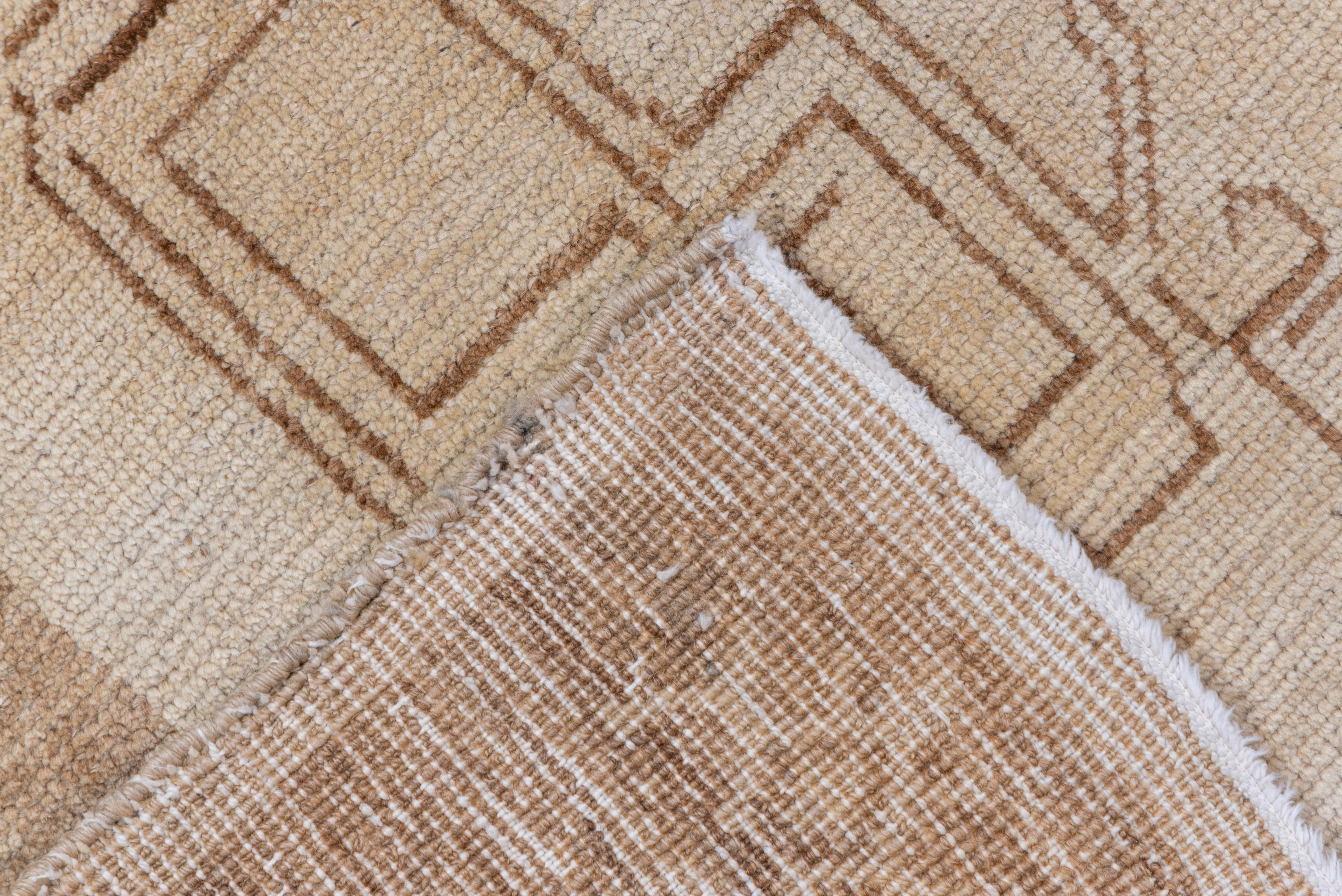 This entirely plain field rustic carpet shows a wheat coloured expanse controlled by open fretwork beige corners. Abrashed light to medium-dark russet brown border with a star chain. Infinite furniture placement. Moderately coarse woven. Good