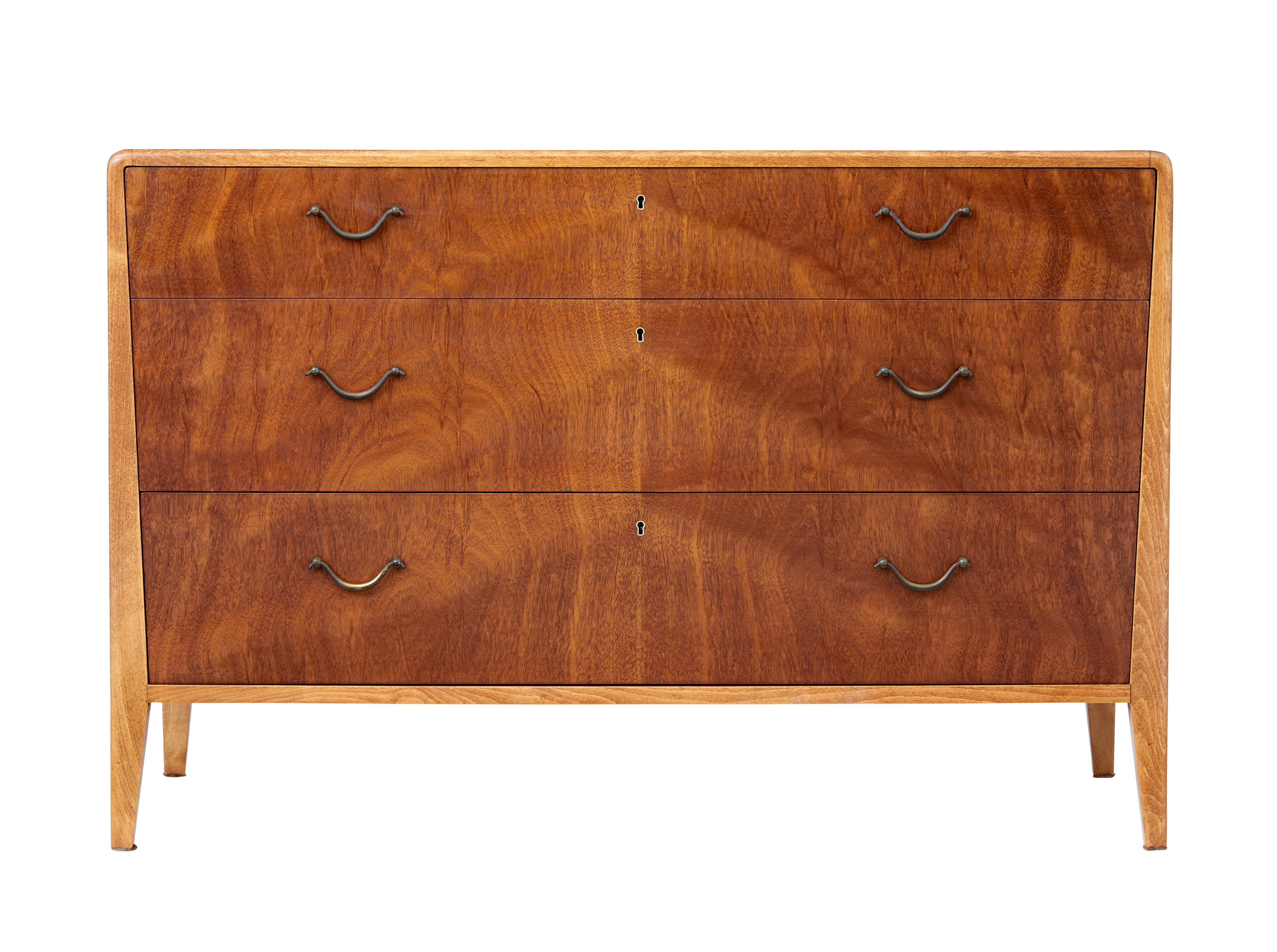 Elegant mahogany chest of drawers, circa 1950.

3 drawers with tapering width and original brass modern swan neck handles. Outer frame in lighter wood to provide a stylish contrast.

Top drawer fitted with partitions which can be