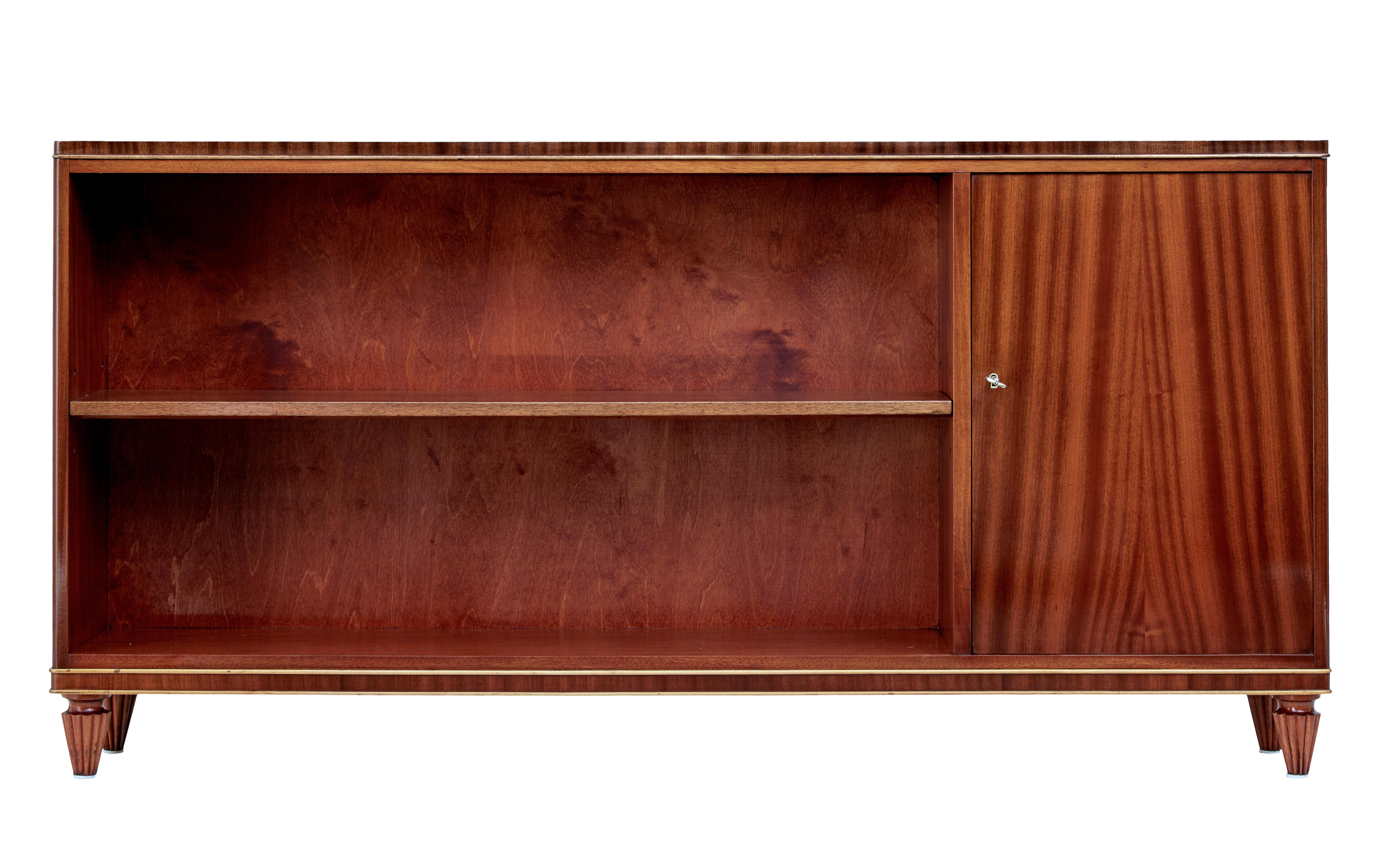 Mid-20th century Scandinavian mahogany open bookcase circa 1950.

Stylish bookcase cupboard combination. Single door cupboard to the left with matched flame mahogany veneers which opens to a single shelf. Main aperture for book storage with a