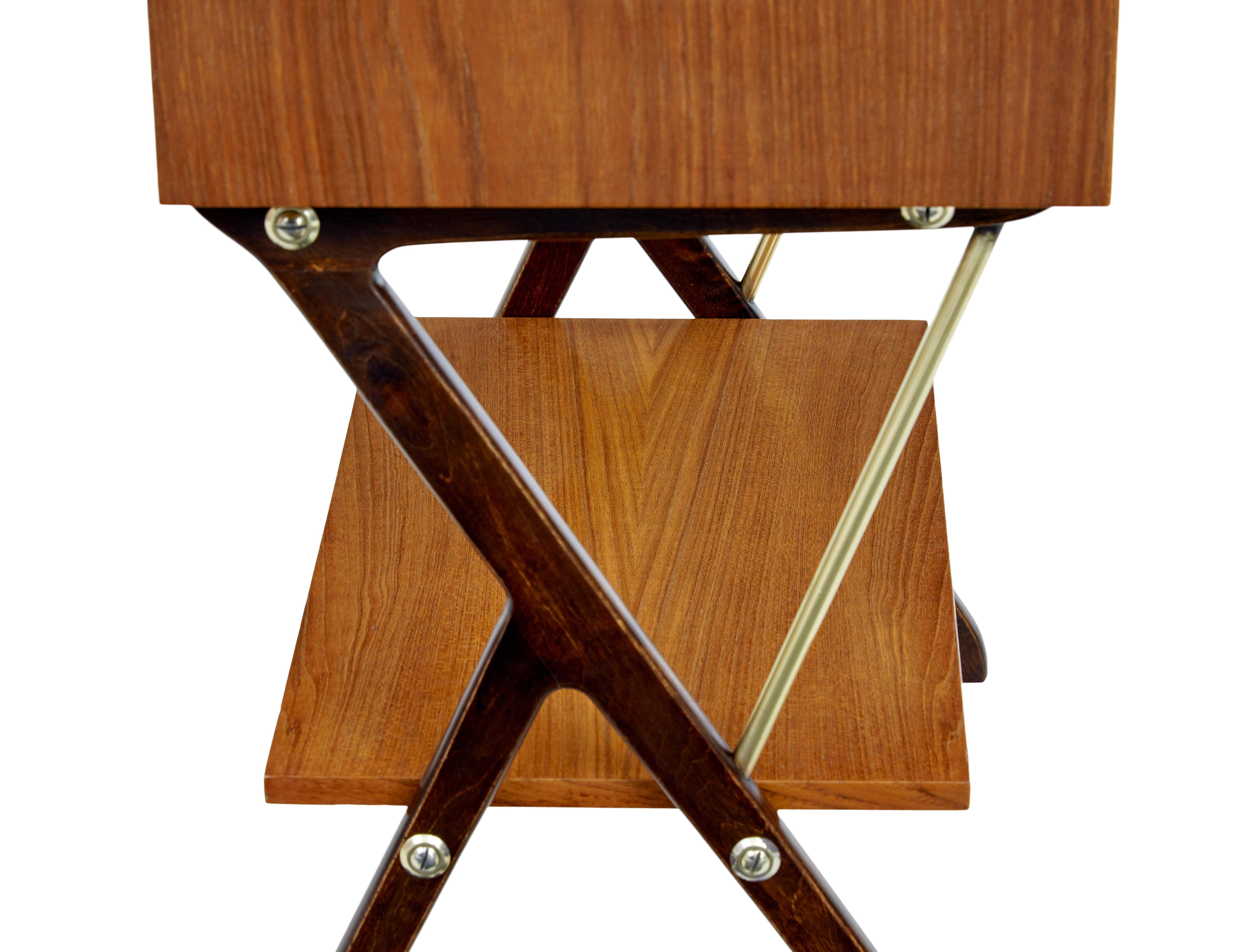 Mid 20th century Scandinavian modern teak side table circa 1960.

Teak side table with 2 front drawers. Formica inlaid top and dark stained standing on y frame legs which supports a further storage shelf.

Recently re-polished in our workshop and