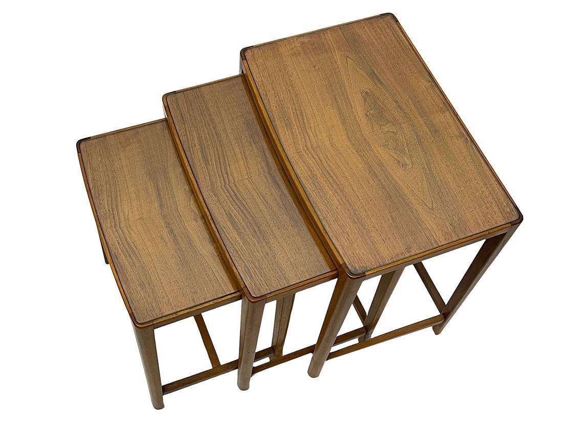 Mitte des 20. Jahrhunderts Skandinavischer Nisttischsatz

Ein Satz skandinavischer Nisttische in heller Nussholzfarbe. 
Rechteckige Tische mit einer leicht gebogenen Form an der Vorderseite. Die drei Tische haben eine Glasplatte. 
Das Maß ist 50 cm