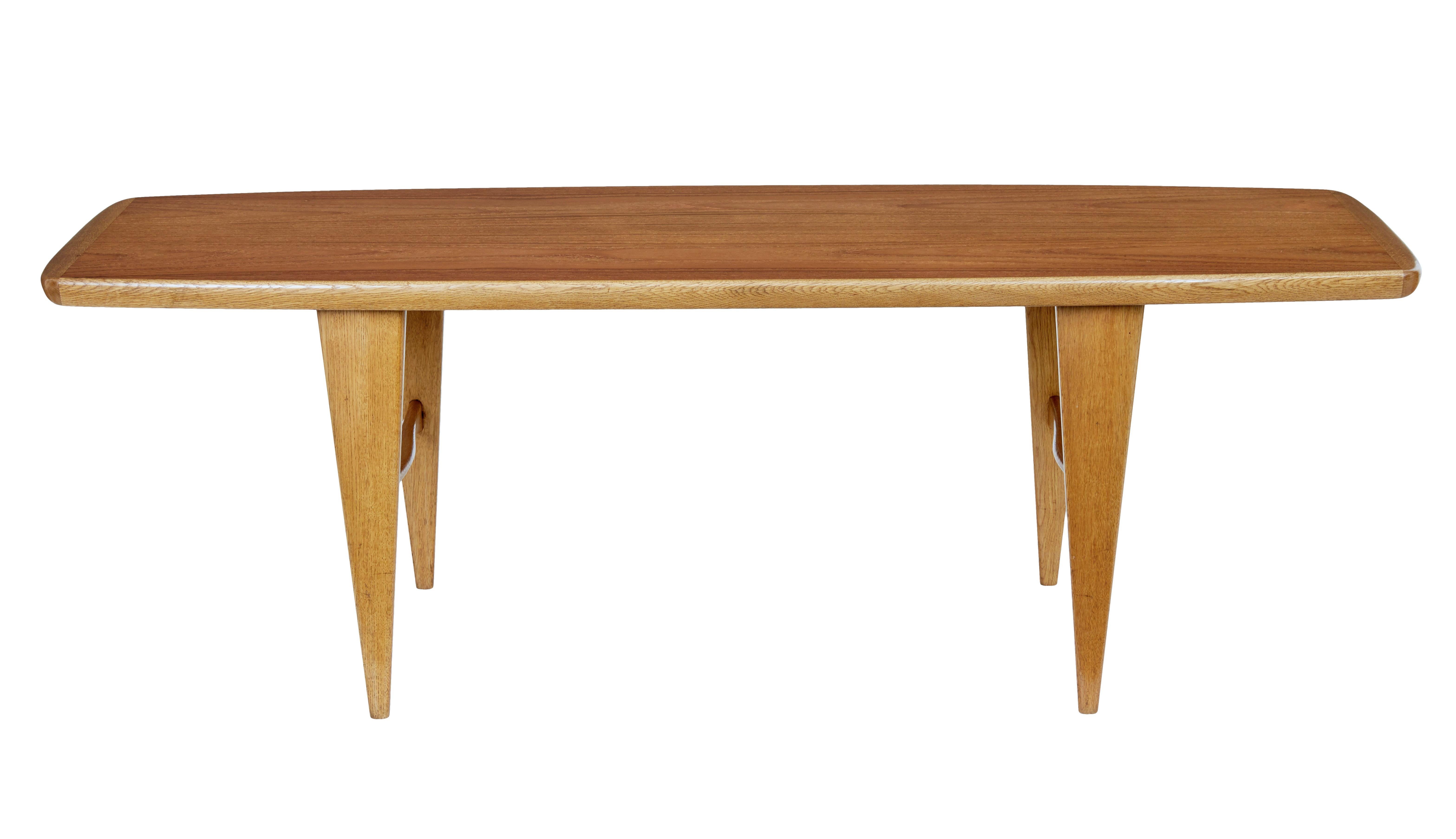 Mid-20th century Scandinavian teak coffee table, circa 1960.

Stylish teak and oak shaped coffee table. Teak top with oak border. Standing on tapered oak legs united by a shaped h frame stretcher.

Minor surface fading to top. Recently