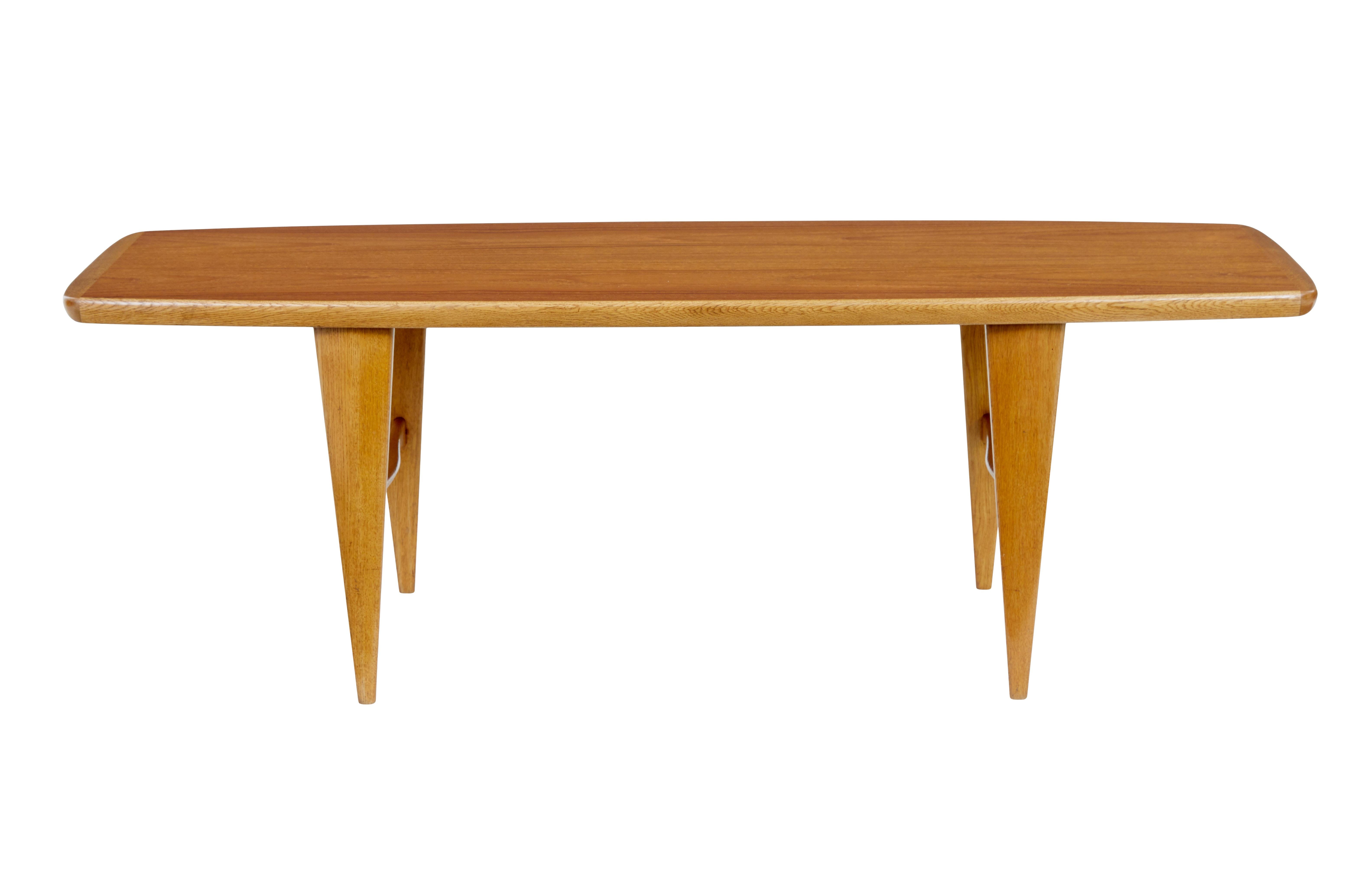 Mid 20th century Scandinavian teak coffee table circa 1960.

Stylish teak and oak shaped coffee table.  Teak top with oak border.  Standing on tapered oak legs united by a shaped h frame stretcher.

1 area of minor surface wear to top, couple of