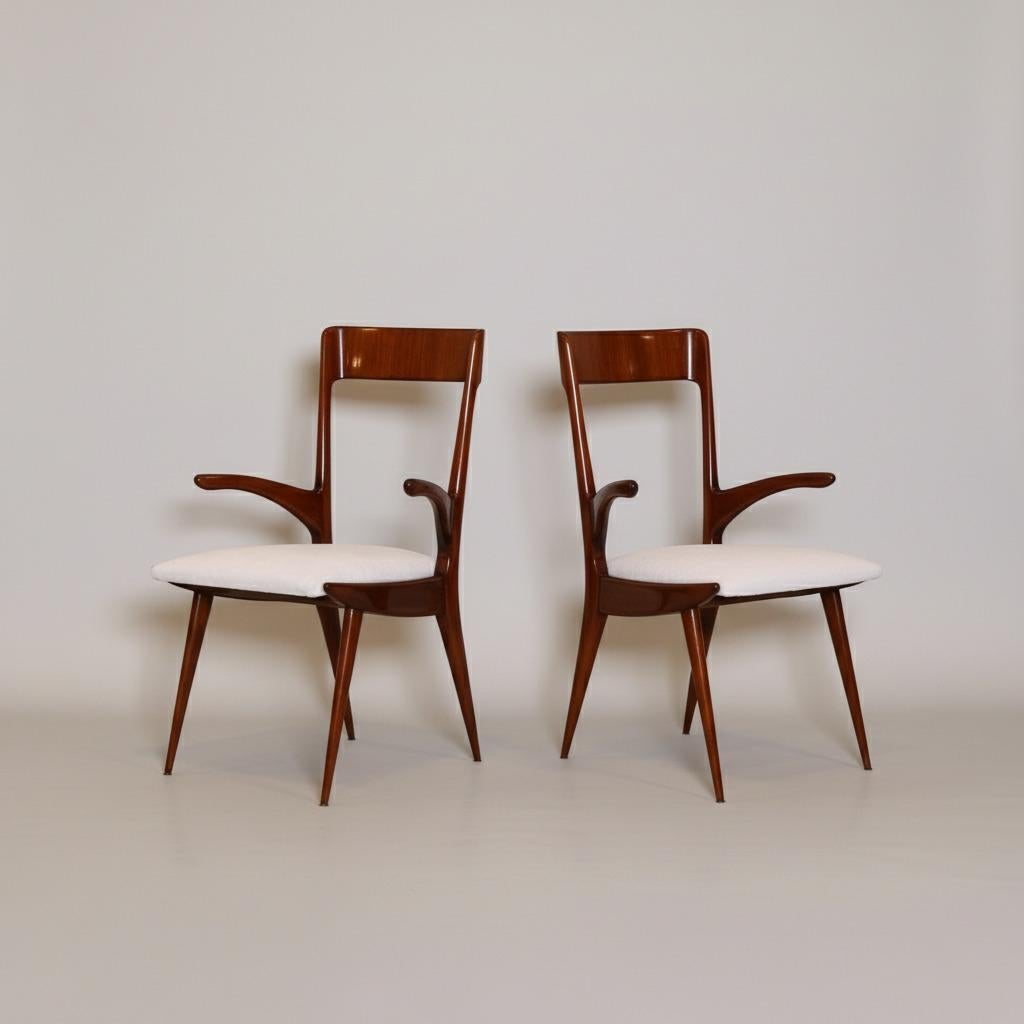 Satz von acht skulpturalen Sesseln mit markanten Profilen. Die Rückenlehne, die Arme und die Beine sind aus massivem Palisanderholz geschnitzt. Die großzügig gepolsterten Sitze sind mit weißem Chenille bezogen. Vollständig restauriert und