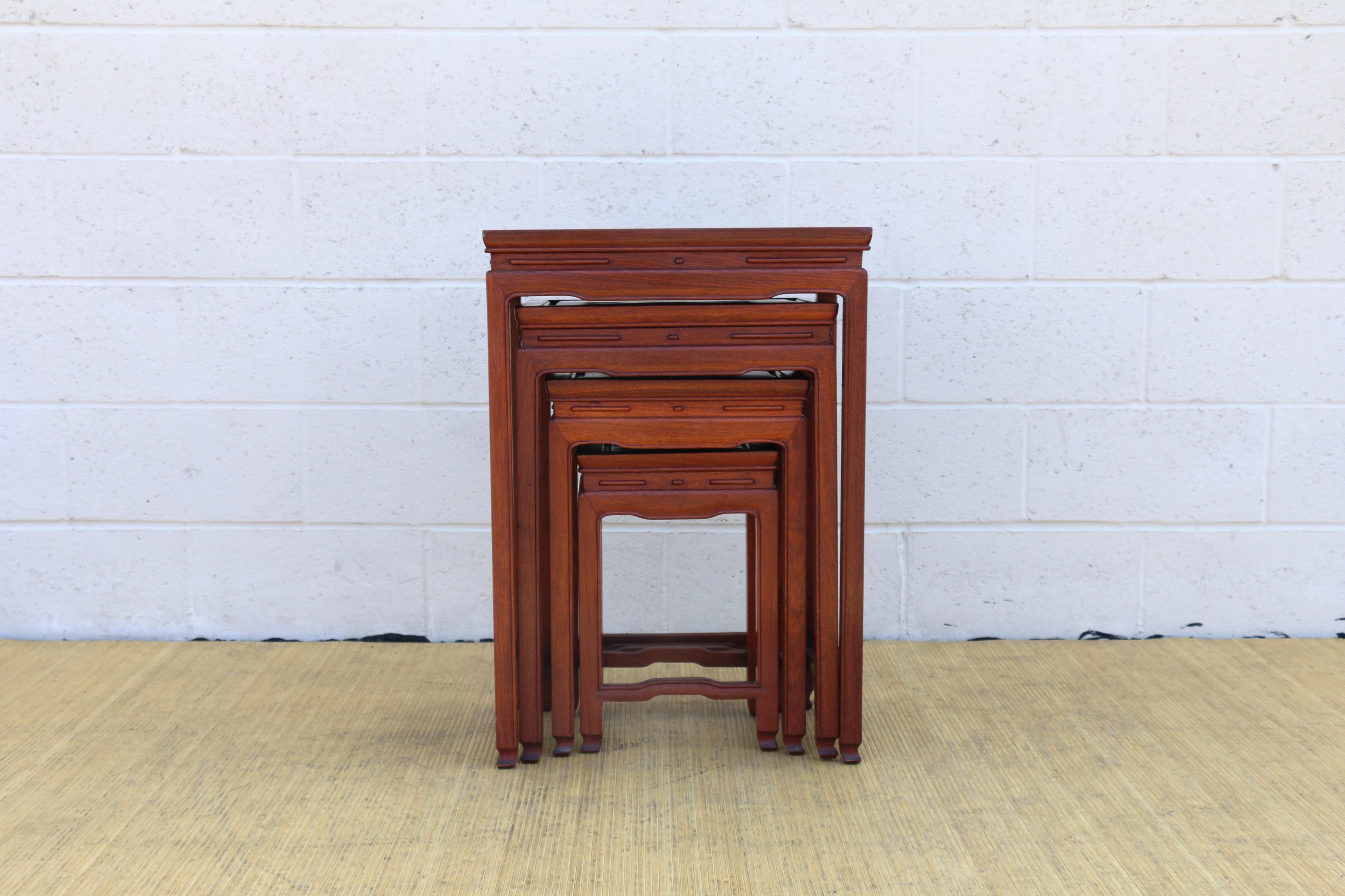 Beautiful set of four vintage Chinese rosewood nesting side tables for George Zee and Co. ( the smallest one has the label in the bottom, shown in the picture). They are originally from the mid-20th century with dark reddish brown patina, curving