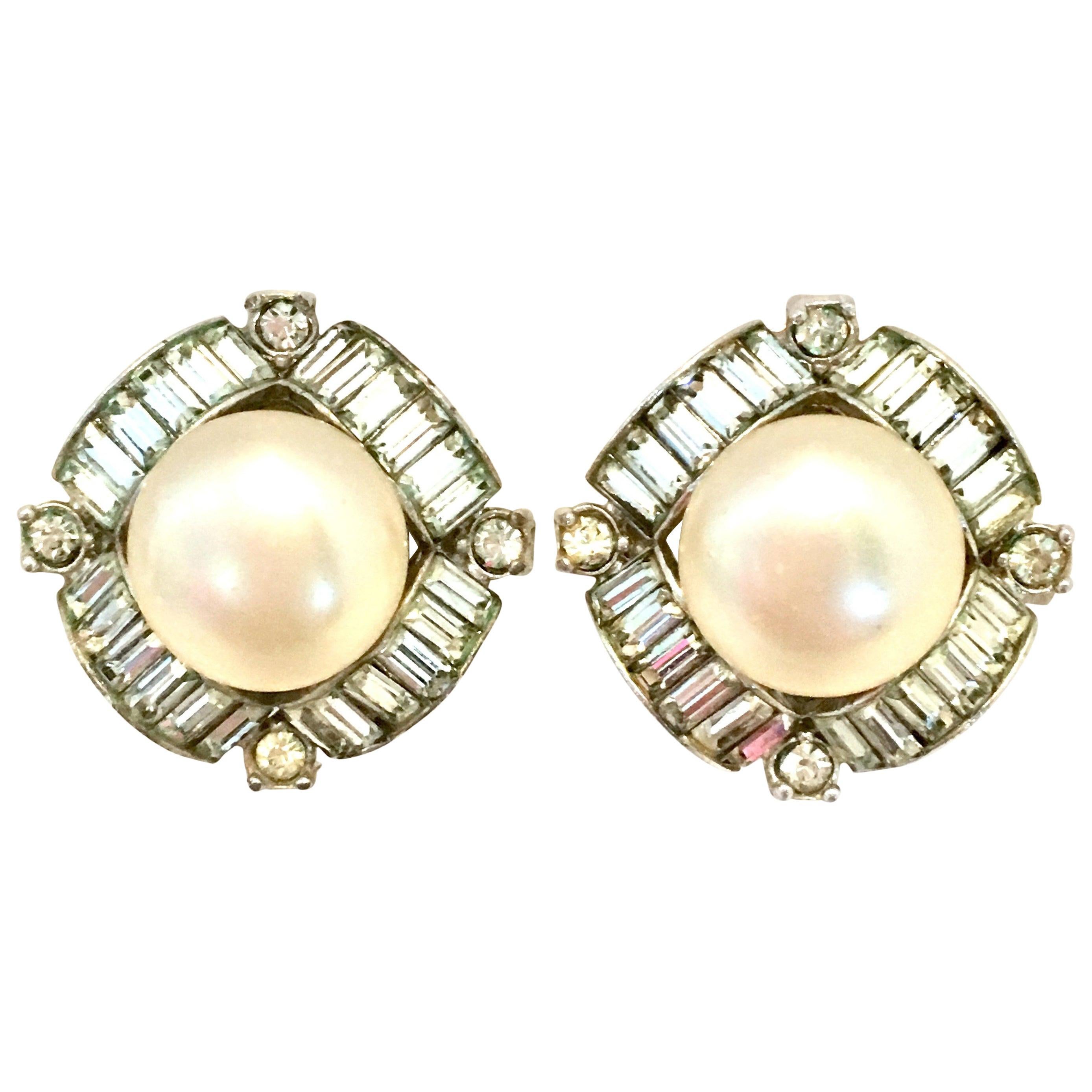 Md-20th Century Silver Plate Faux Pearl & Austrian Crystal Earrings By, Marvella. These dramatic, classic and finely crafted clip style silver plated earrings feature a central and large round faux pearl, surrounded by paste set brilliant baguette