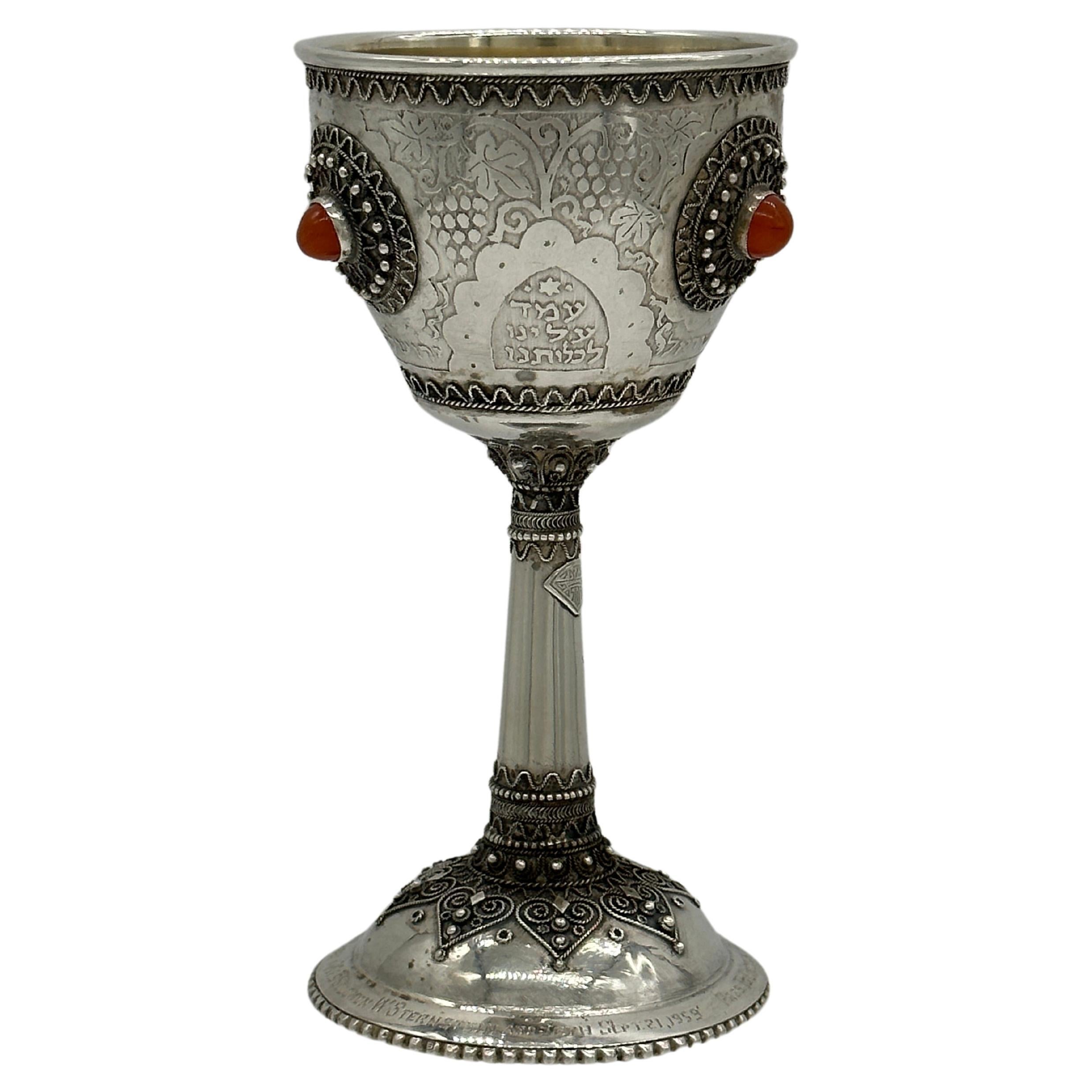 Important Handmade sterling silver Kiddush (eliyahu hanavi cup)  goblet by Bezalel School, Jerusalem, circa 1948.  On round base decorated with silver filigree and Cabouchon shaped orange agate applications.  The base stem with Bezalel mark. The