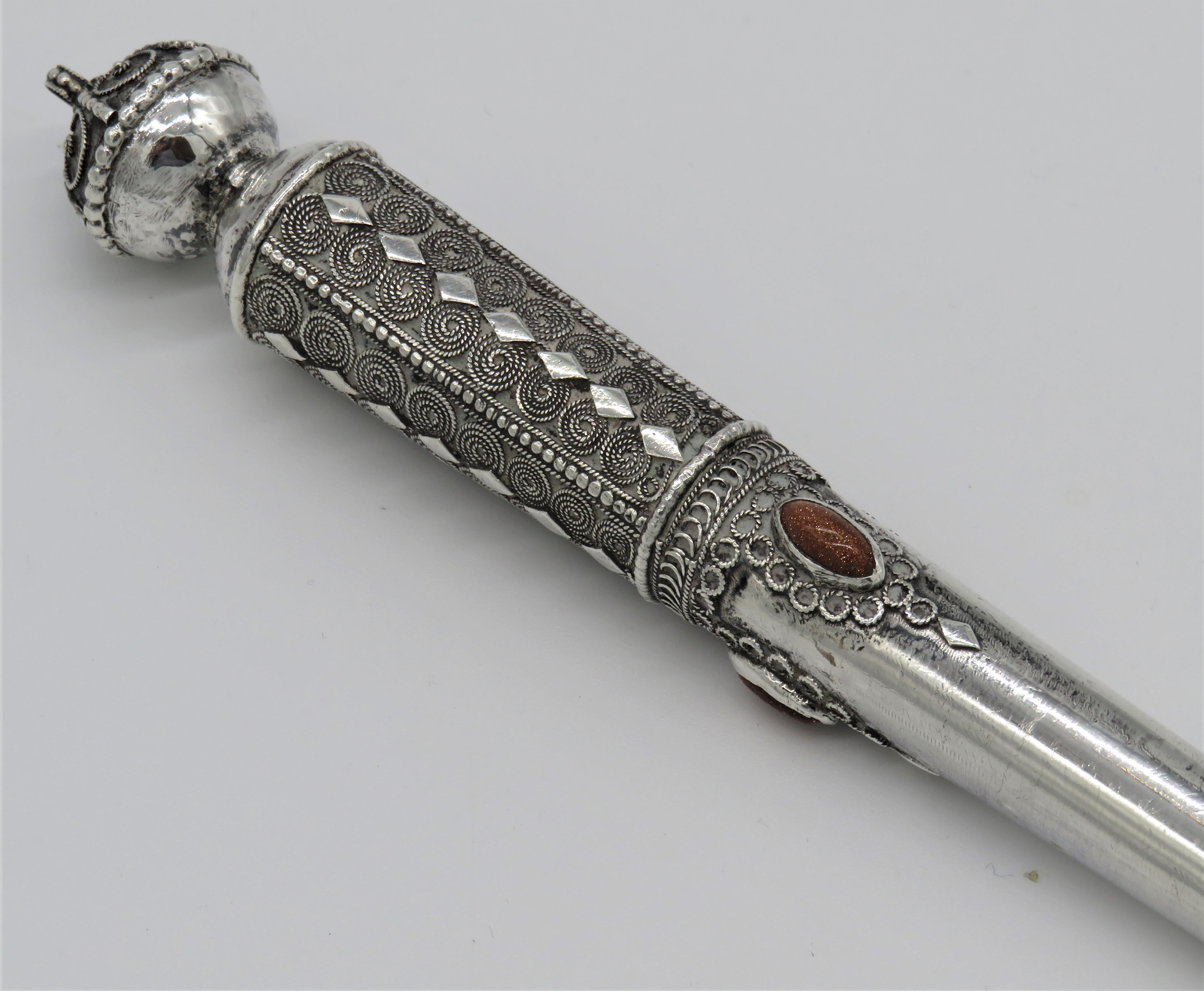 Handmade silver and silver filigree Torah pointer, Yehia Yemini, Jerusalem, circa 1940.
Decorated with Yemeni design, silver filigree work on the top, around the shaft, and next to the finger.
Set with carnelian stones around the shaft.
Stamped on