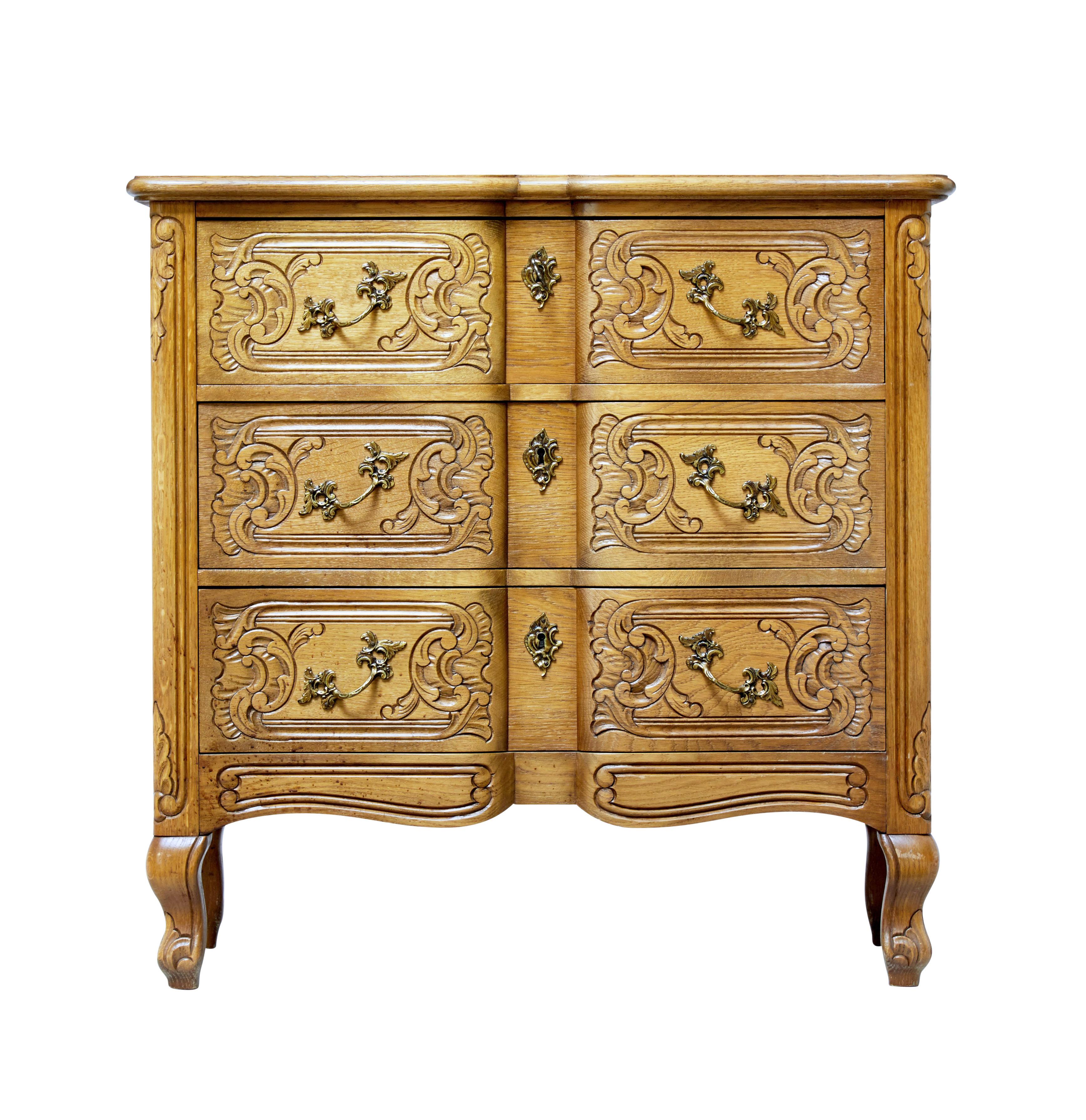 Carved oak commode of small proportions, circa 1950.

Practical small chest of drawers in the Baroque taste. 3 block fronted drawers with carving in the solid. With decorative handles.

Light oak color.

Restoration to veneer on back edge,