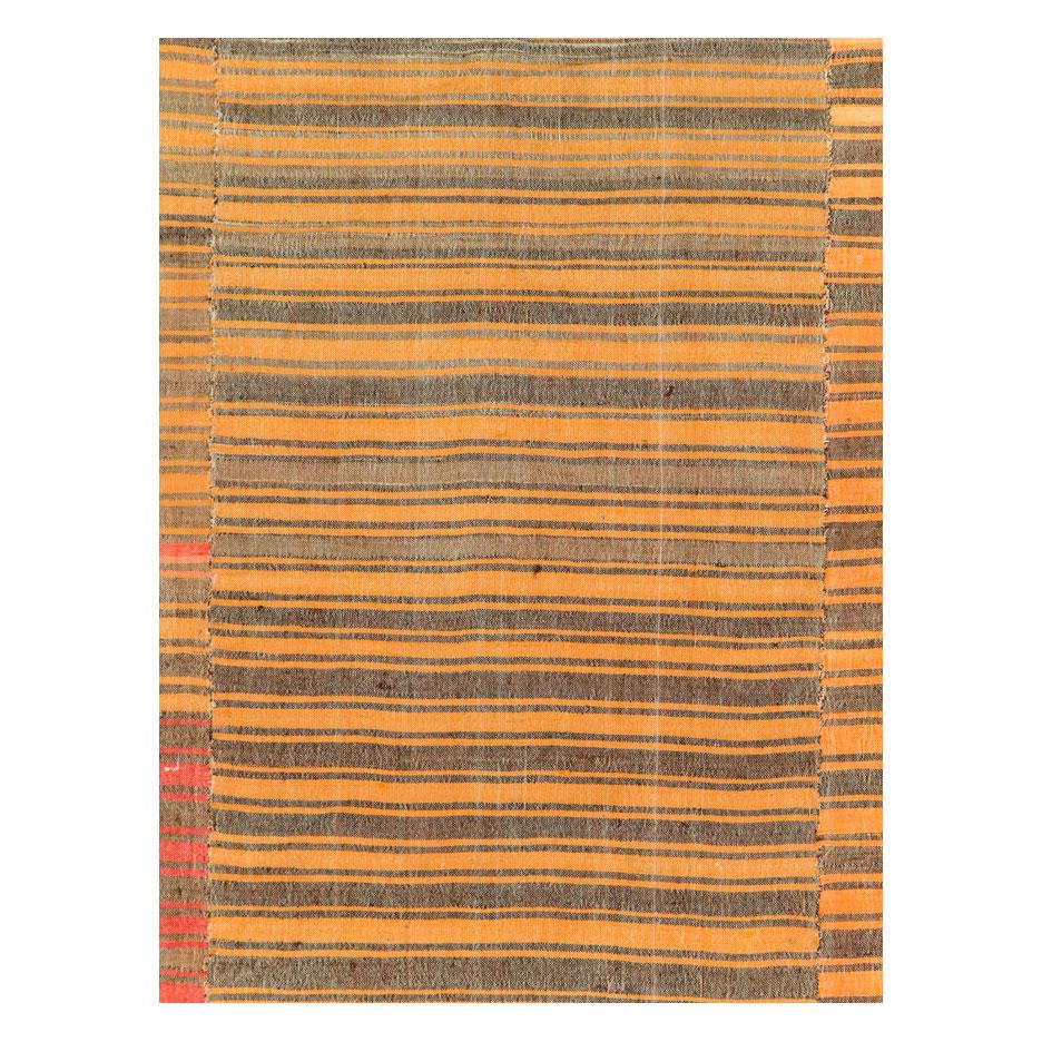 A vintage Turkish flat-weave Kilim small room size accent rug handmade during the mid-20th century with a striped pattern in shades of yellow and red-orange.

Measures: 6' 9