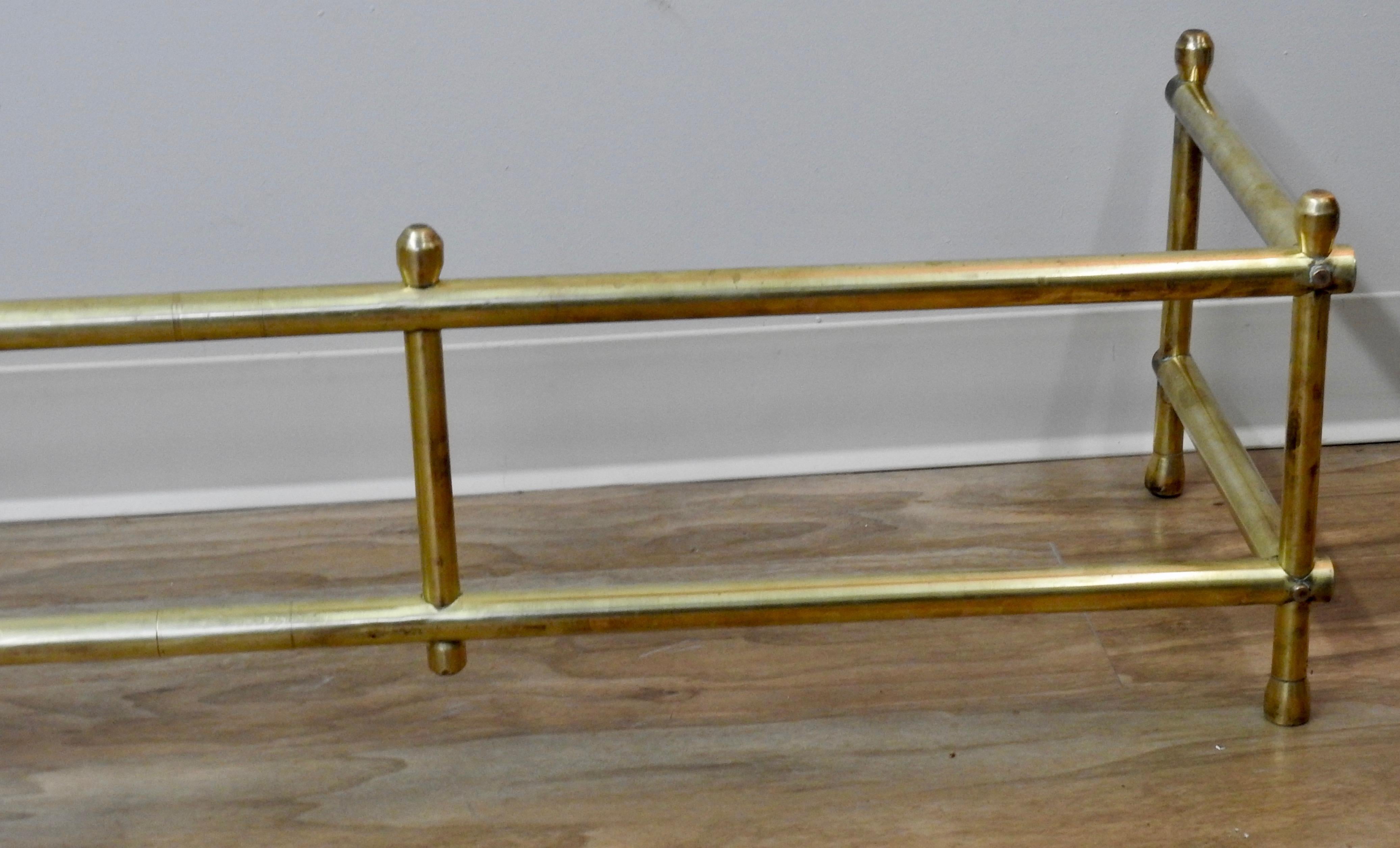 This beautiful 20th century solid brass fireplace surround is simple. Clean lines with a statement. It starts on a small tapered bun foot. Going up in simple vertical and horizontal lines capped with the same top as the feet.