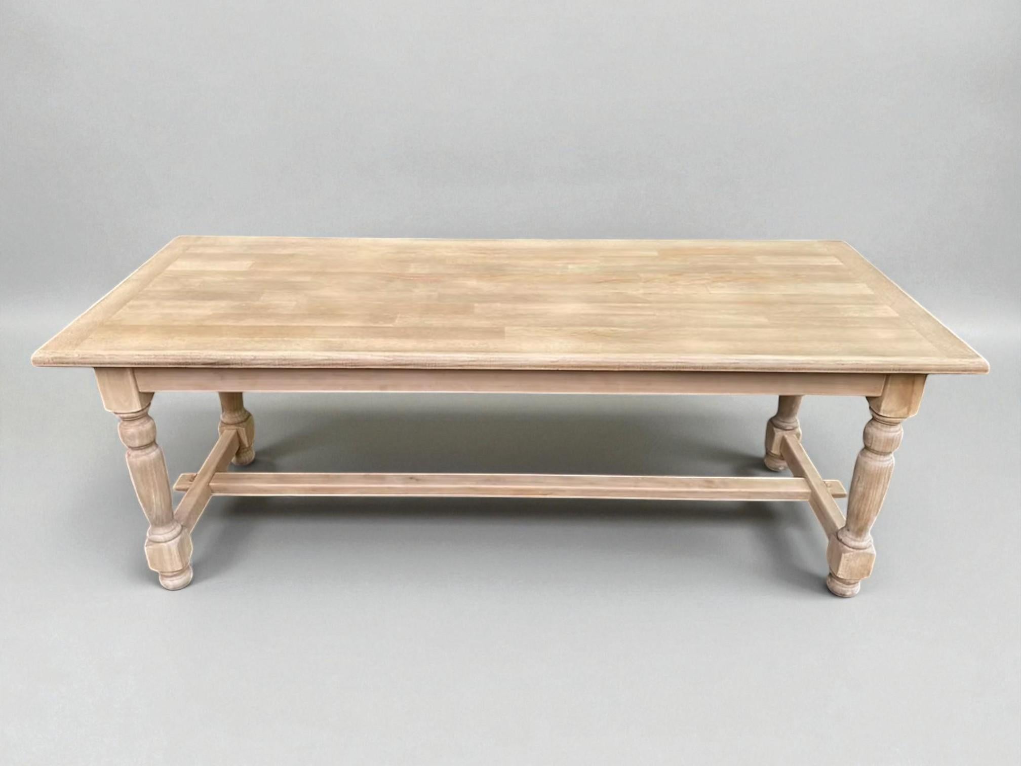 Cette élégante table de style réfectoire, fabriquée en chêne massif, est finie dans un doux ton de chaux blanche qui met en valeur son grain tout en lui conférant une présence légère et contemporaine. Le plateau rectangulaire présente un arrangement