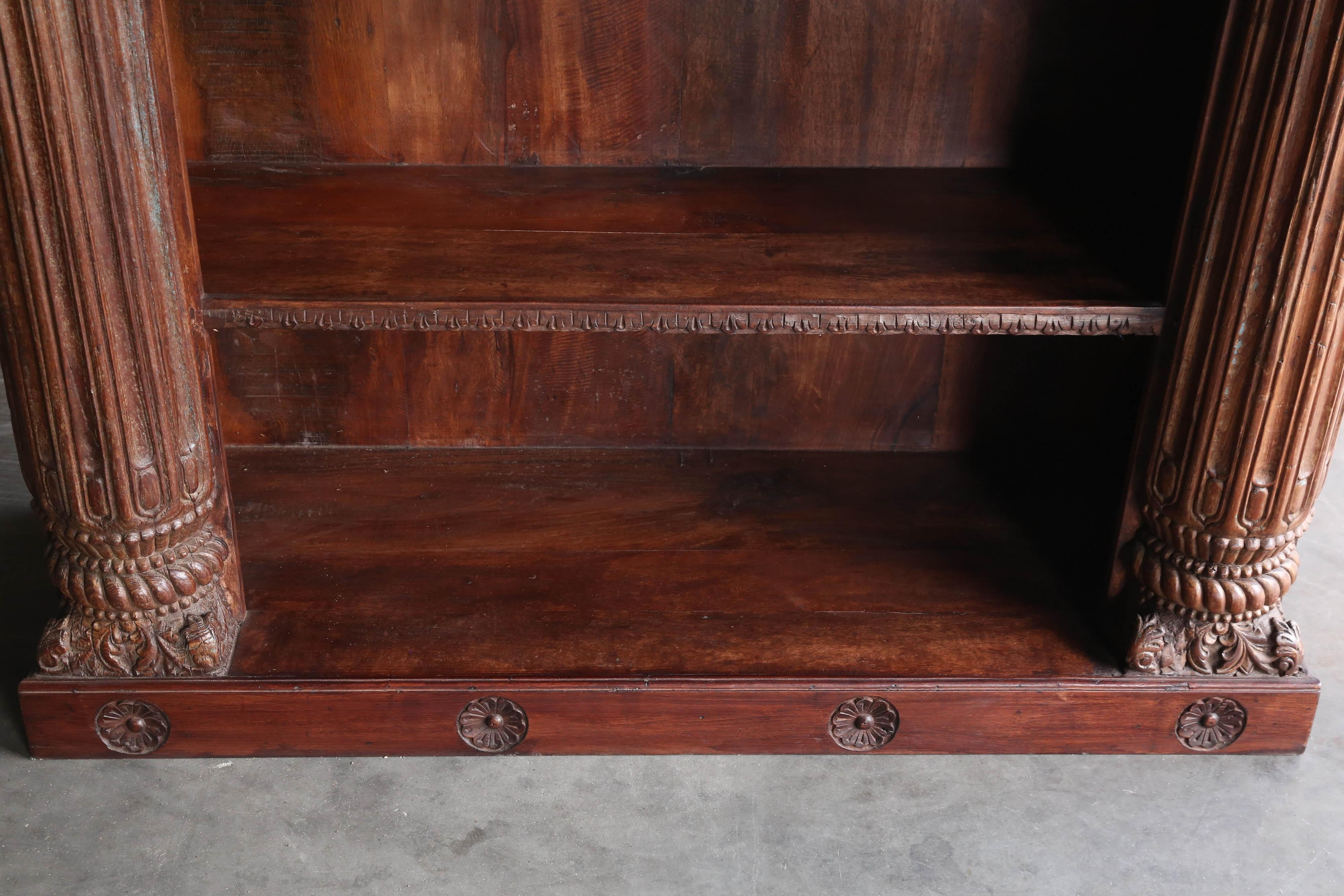 This is a massive open bookcase made from seasoned solid teak wood. It has five shelves. The two solid teak wood half columns on the sides lends an aura of grandeur to the piece. This comes from a British settler’s home in the far east India.