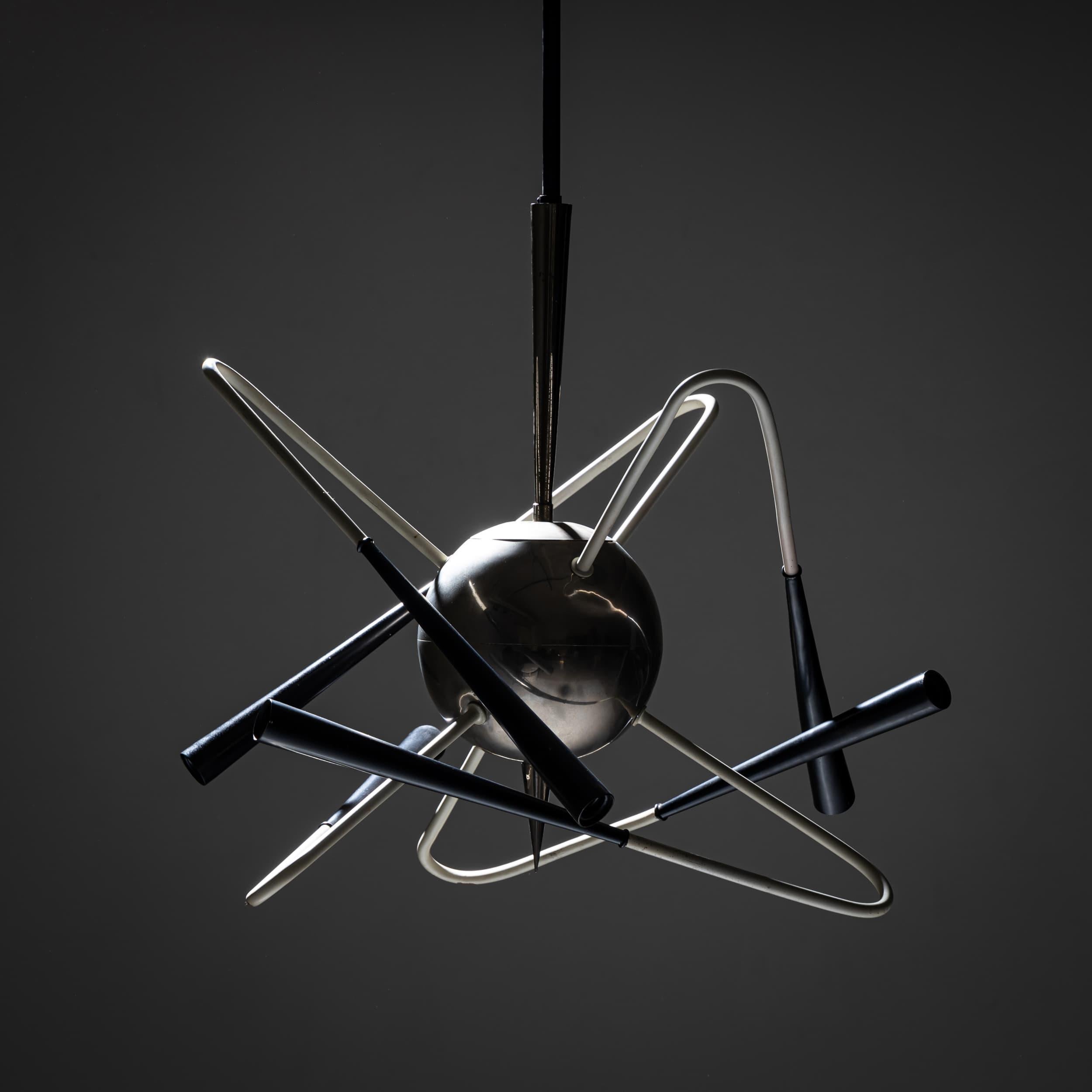 Futuristischer fünfarmiger Space-Age-Kronleuchter mit einer zentralen Aluminiumkugel und elegant geschwungenen Armen mit schwarzen Fassungen. Das Design erinnert an einen Satelliten und verkörpert den innovativen Geist der 1950er Jahre.