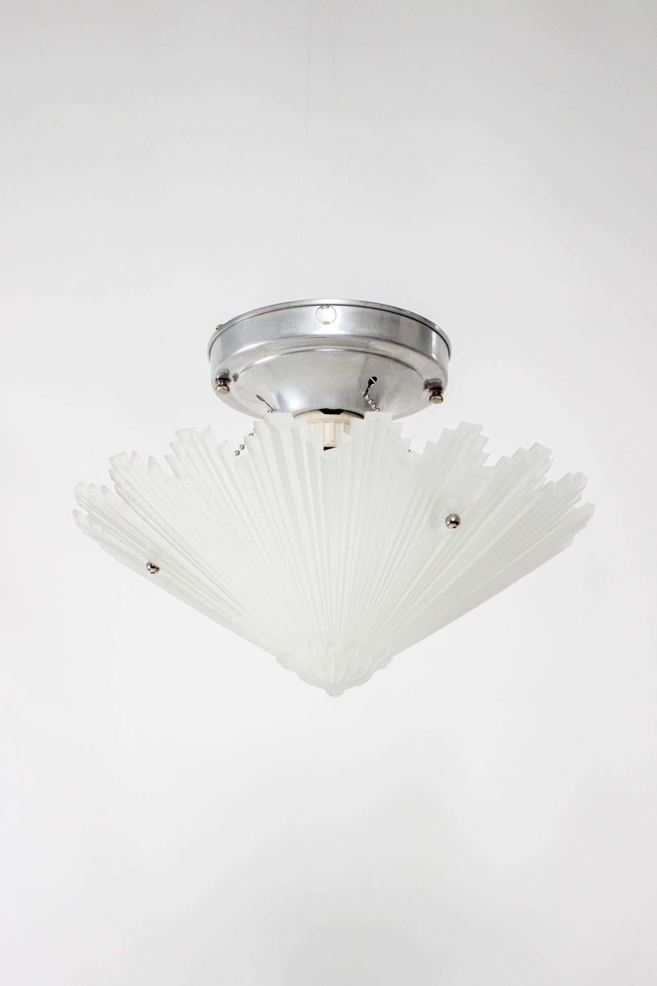 A semi flush fixture with original starburst glass. Cast frosted glass. Aluminum fixture with bead chain fitter. Rewired and ready to install. Glass is in good condition with some small chips due to it’s age, metal has the original cleaned finish.